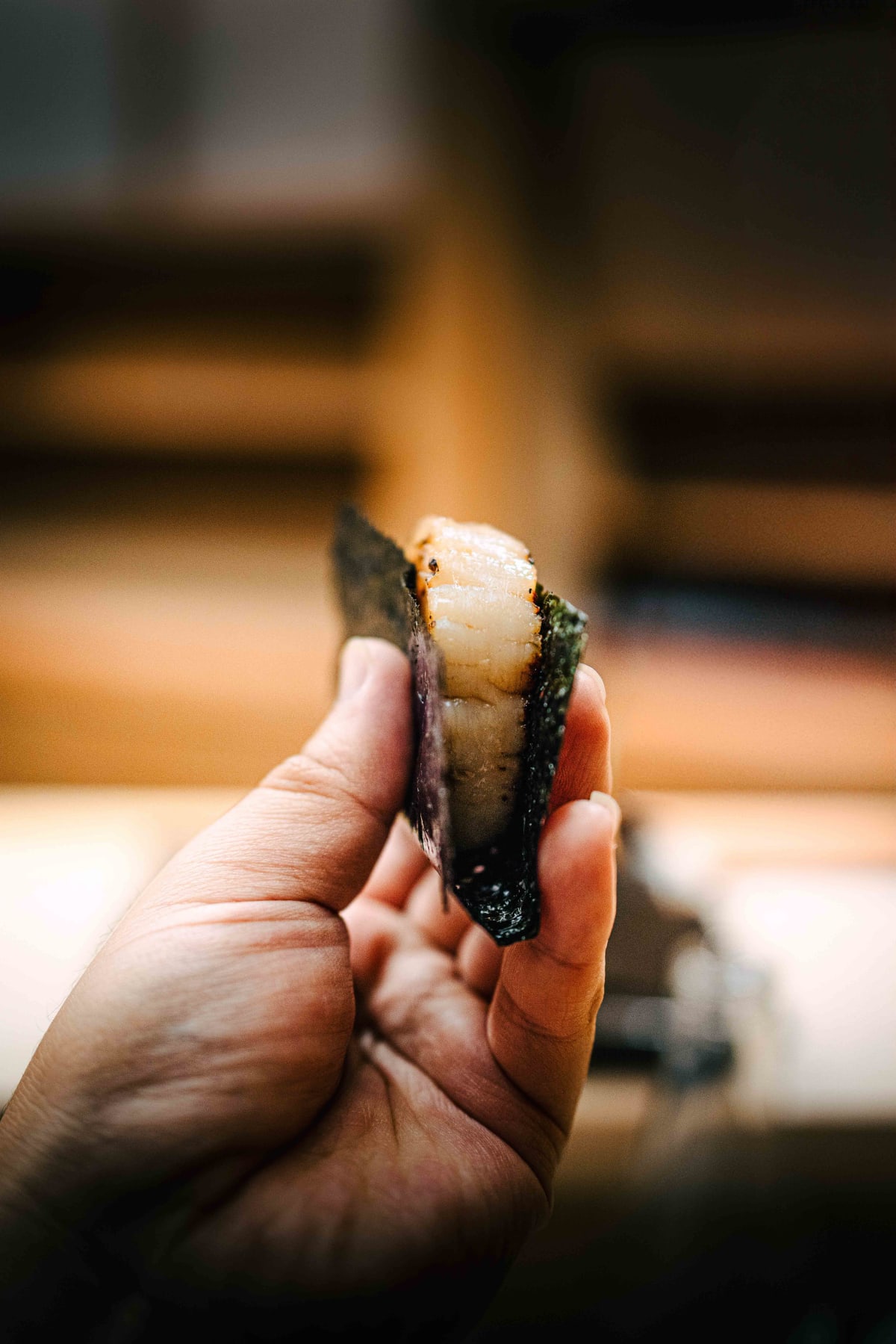 Nihonbashi Kakigaracho Sugita, Tokyo: the cut face of the isobeyaki, the grilled scallop inside the band of nori