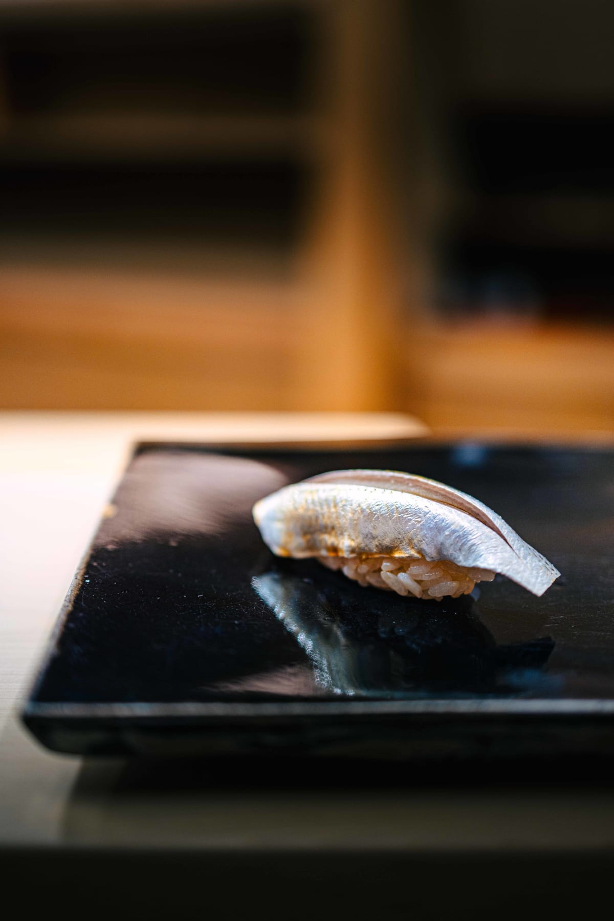 Nihonbashi Kakigaracho Sugita, Tokyo: kohada nigiri, the first piece, its silver skin bright on the black lacquer board