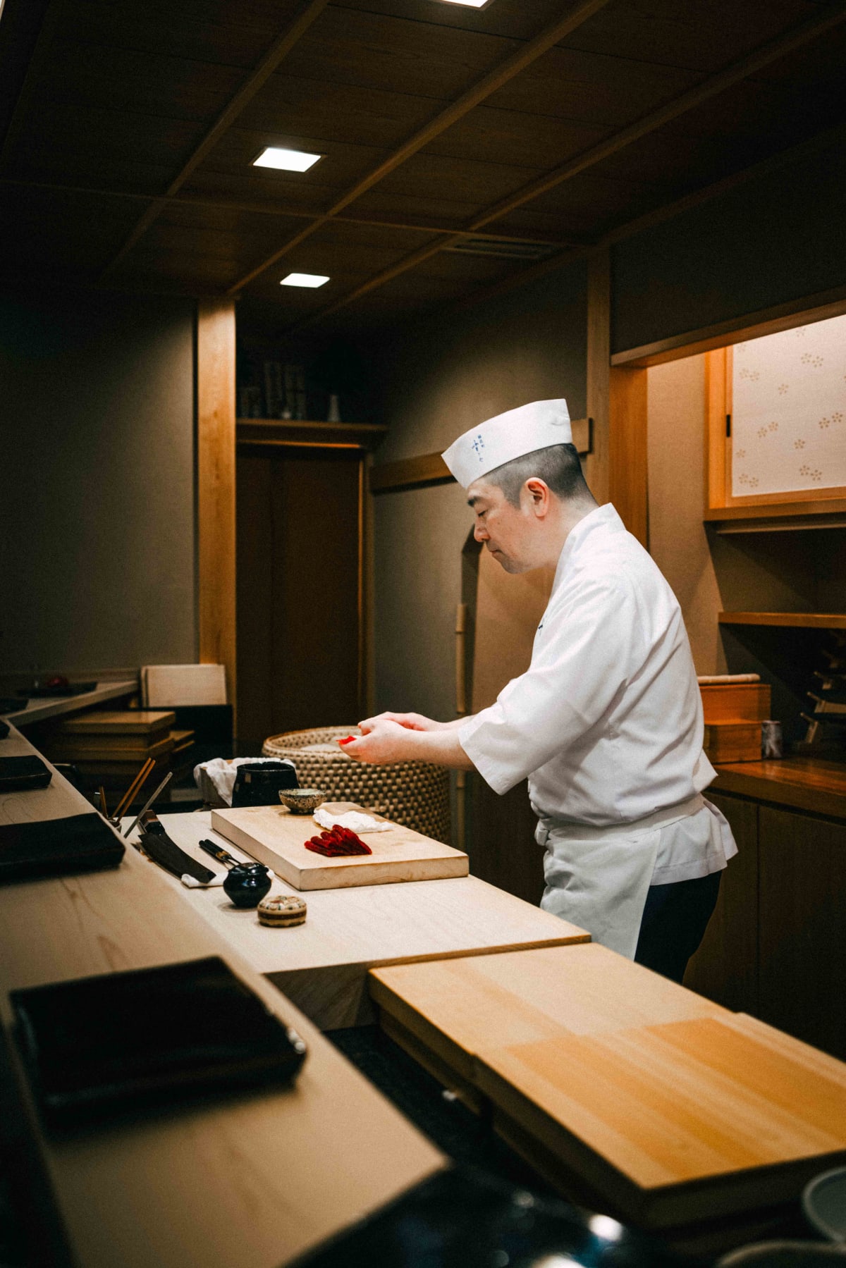 Nihonbashi Kakigaracho Sugita, Tokyo: Sugita shaping nigiri at the counter, head bowed in concentration