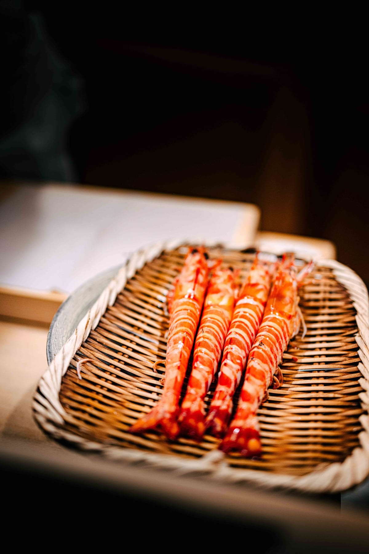 Nihonbashi Kakigaracho Sugita, Tokyo: kuruma ebi boiled and waiting in a bamboo basket, then peeled by hand over a stoneware bowl