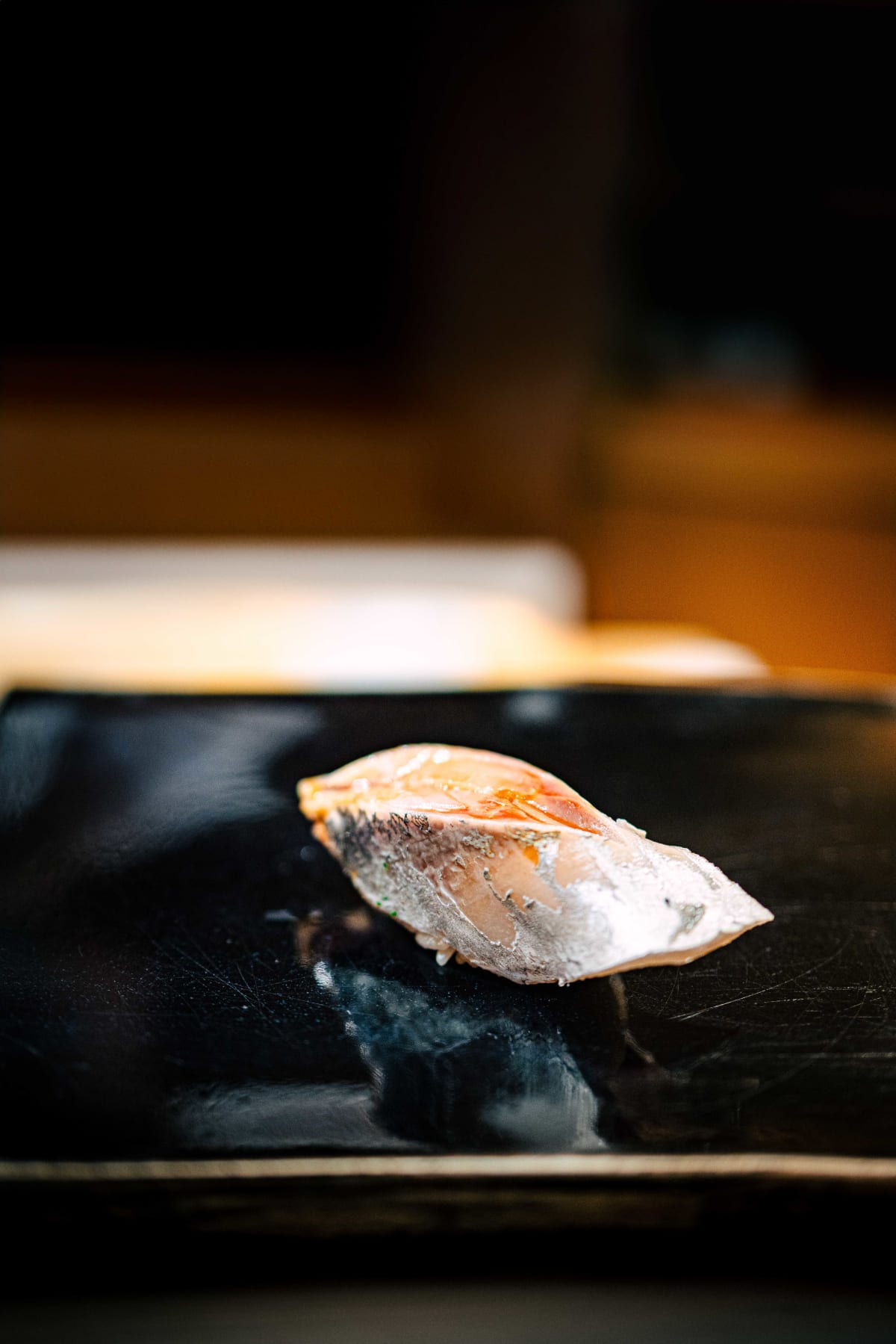 Nihonbashi Kakigaracho Sugita, Tokyo: aji nigiri, silver skin and pink flesh glistening on the black lacquer board