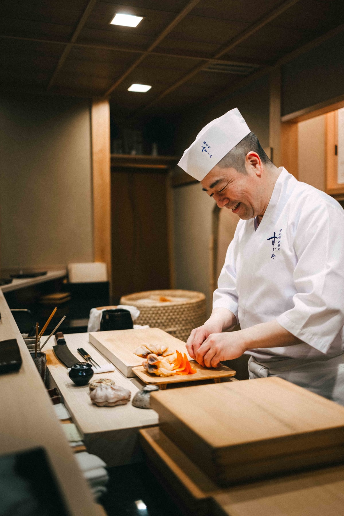 Nihonbashi Kakigaracho Sugita, Tokyo: Sugita smiling as he prepares the extra shellfish at the counter
