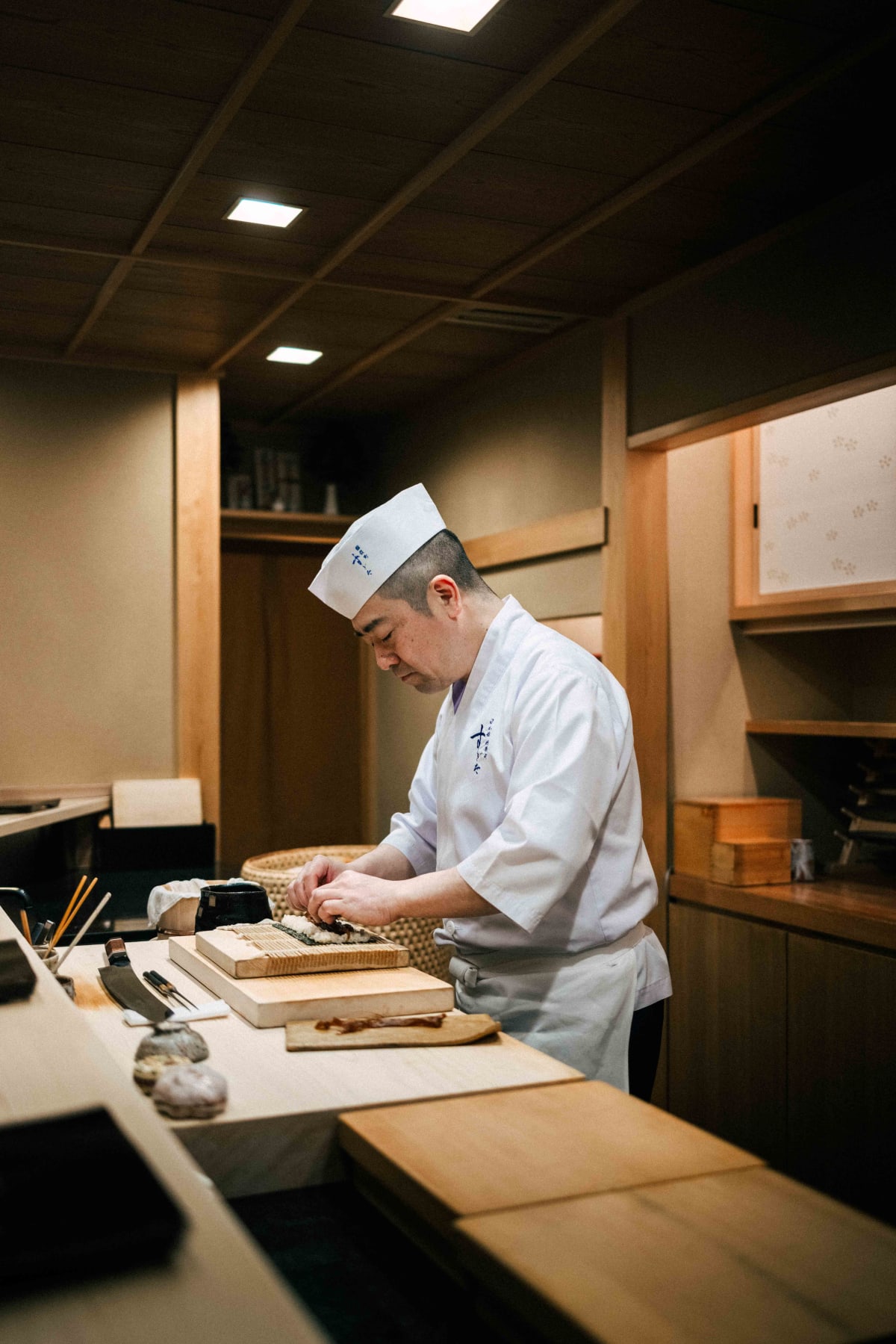Nihonbashi Kakigaracho Sugita, Tokyo: Sugita rolling the maki with a bamboo mat, simmered kanpyo on a plate beside him