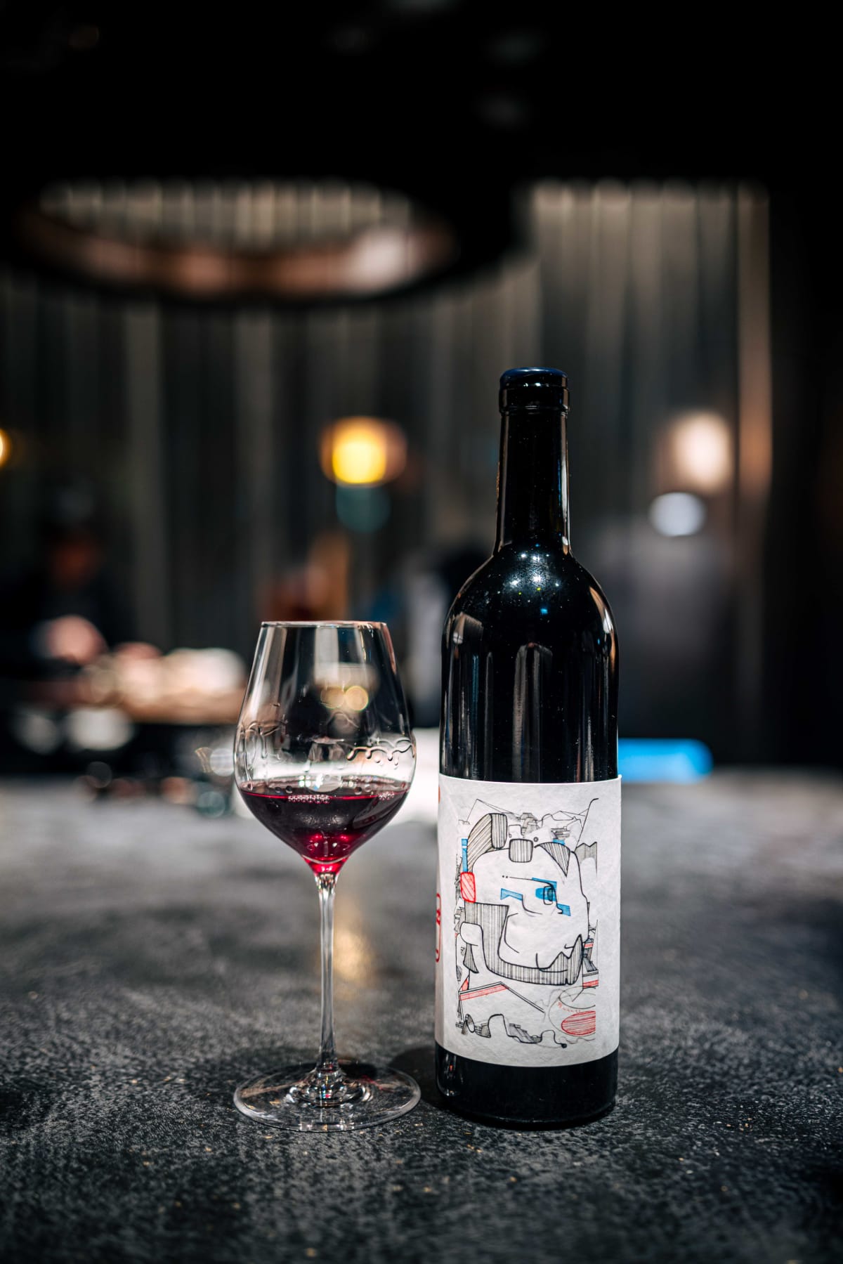 Florilège, Tokyo: the red from 98WINEs, its label covered in a pen drawing, beside a poured glass