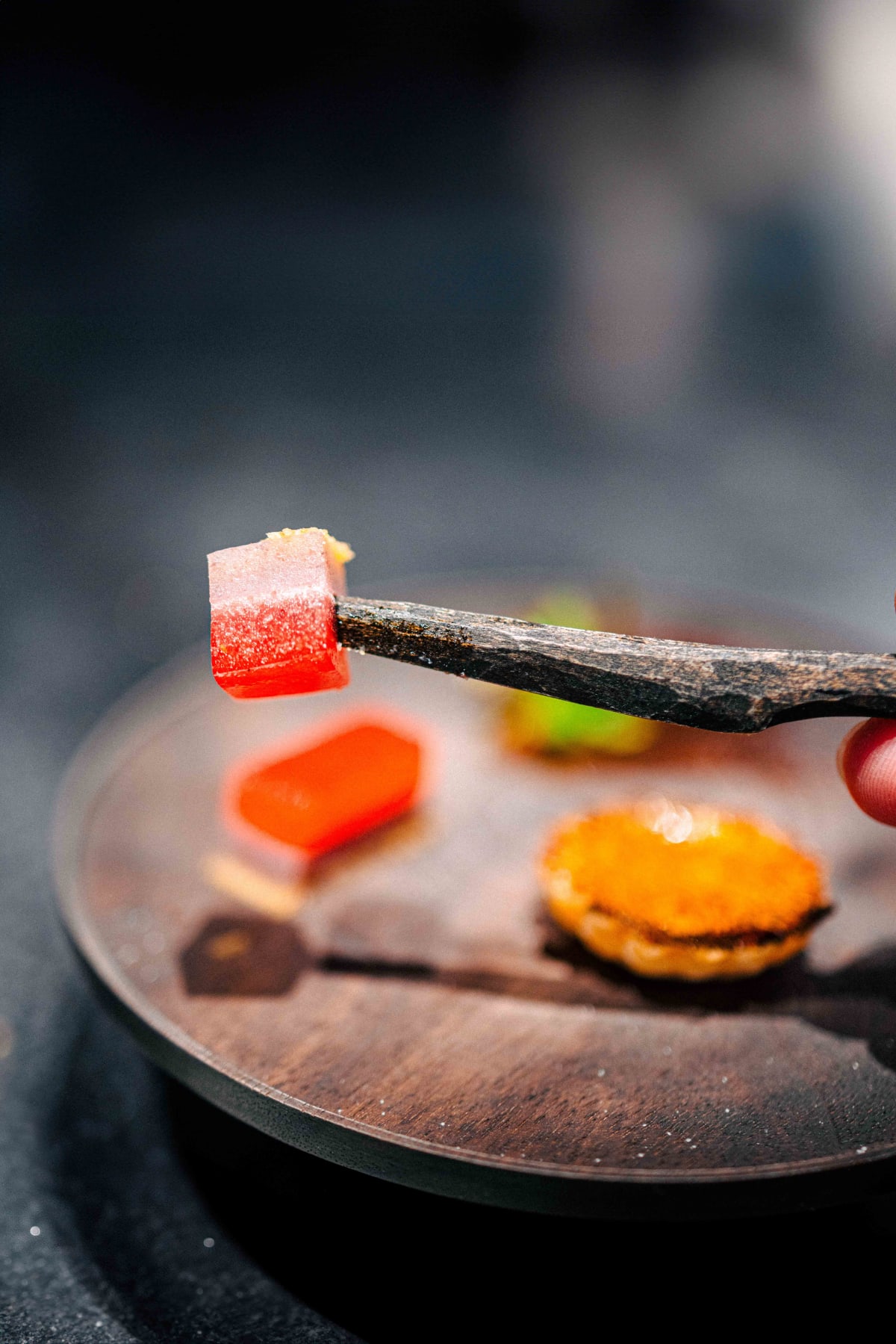 Florilège, Tokyo: pieces of the red jelly bar and the clear jelly, cut and held on the wooden knife