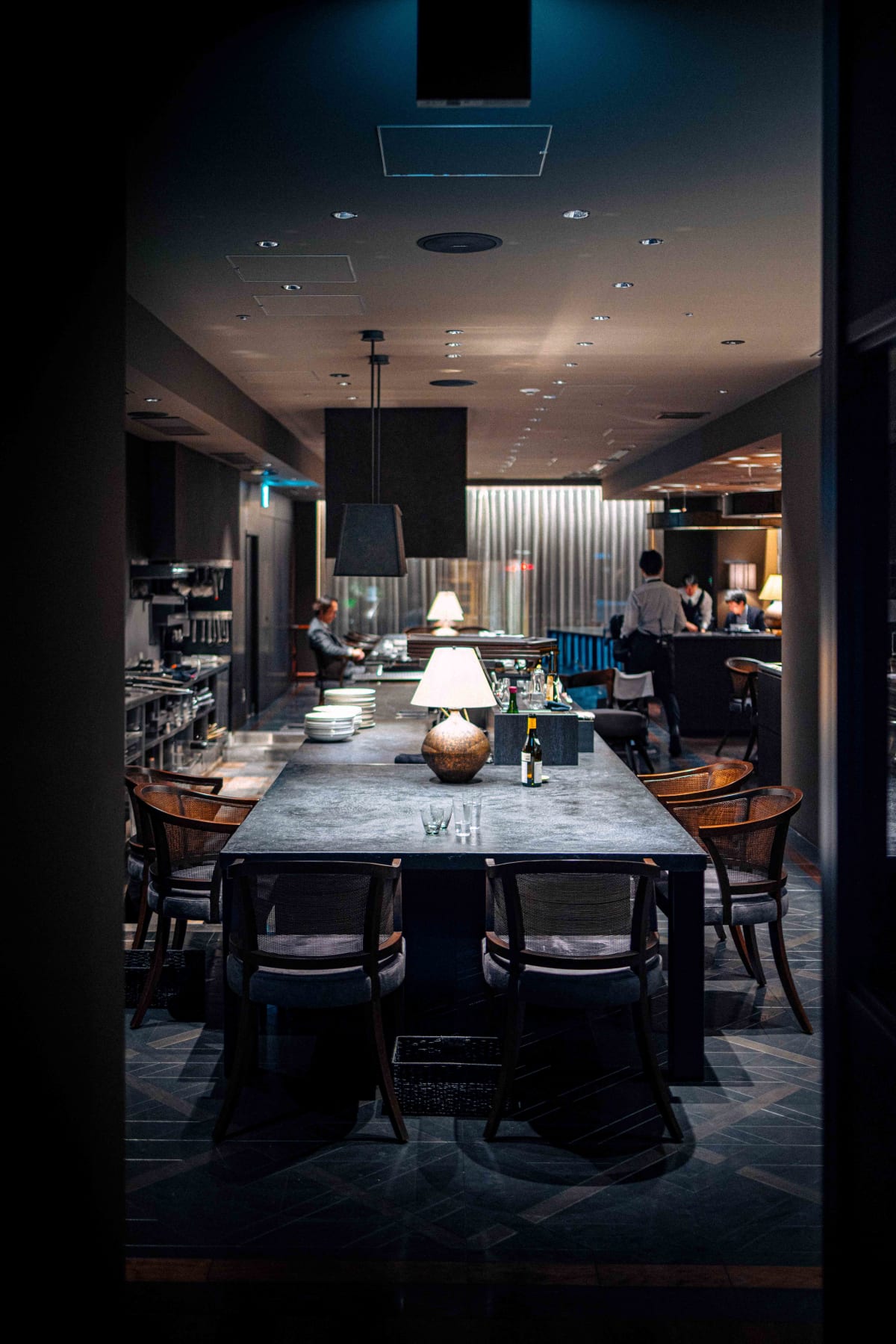 Florilège, Tokyo: the long table and its rattan armchairs, the open kitchen at the far end