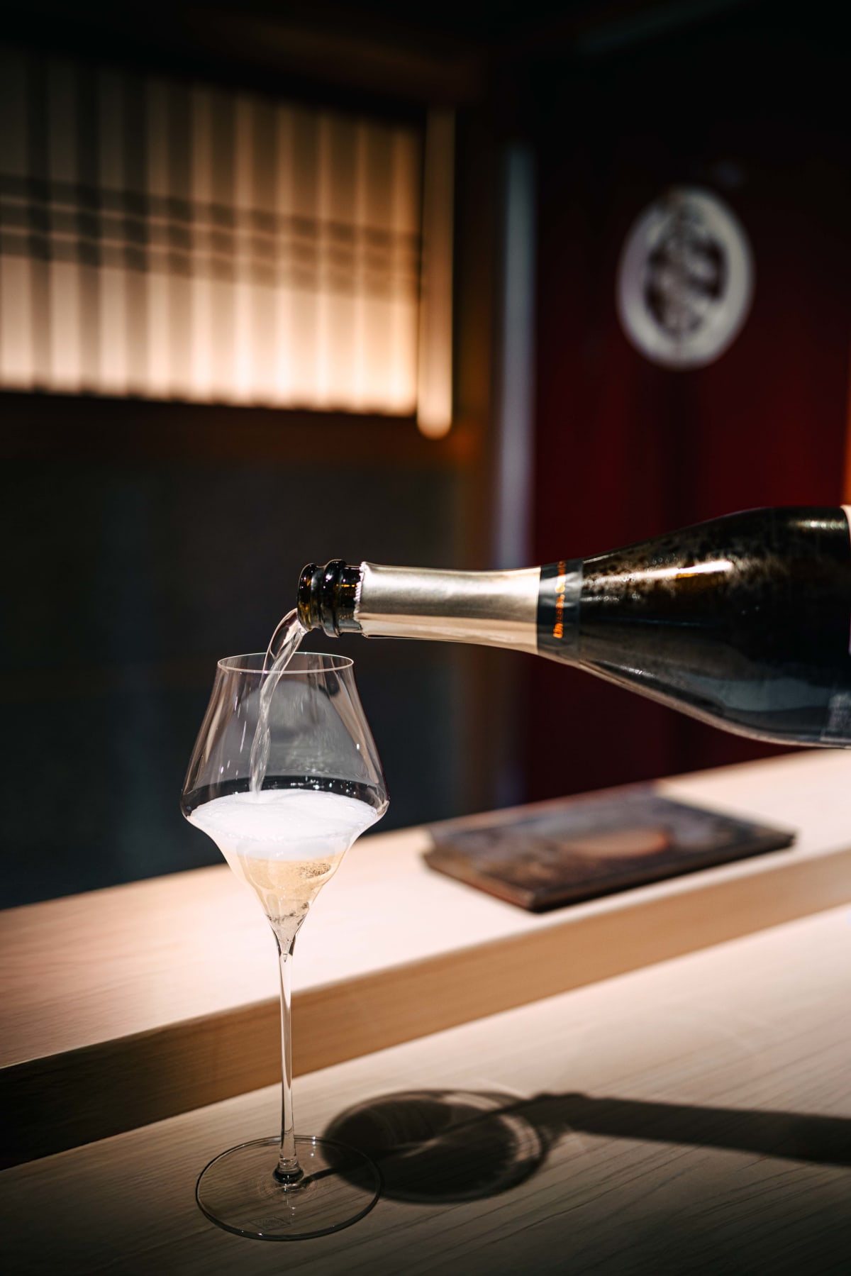 Sushi Juyon by Saito, Seoul: the Champagne being poured against the shoji windows, then two glasses raised in a toast