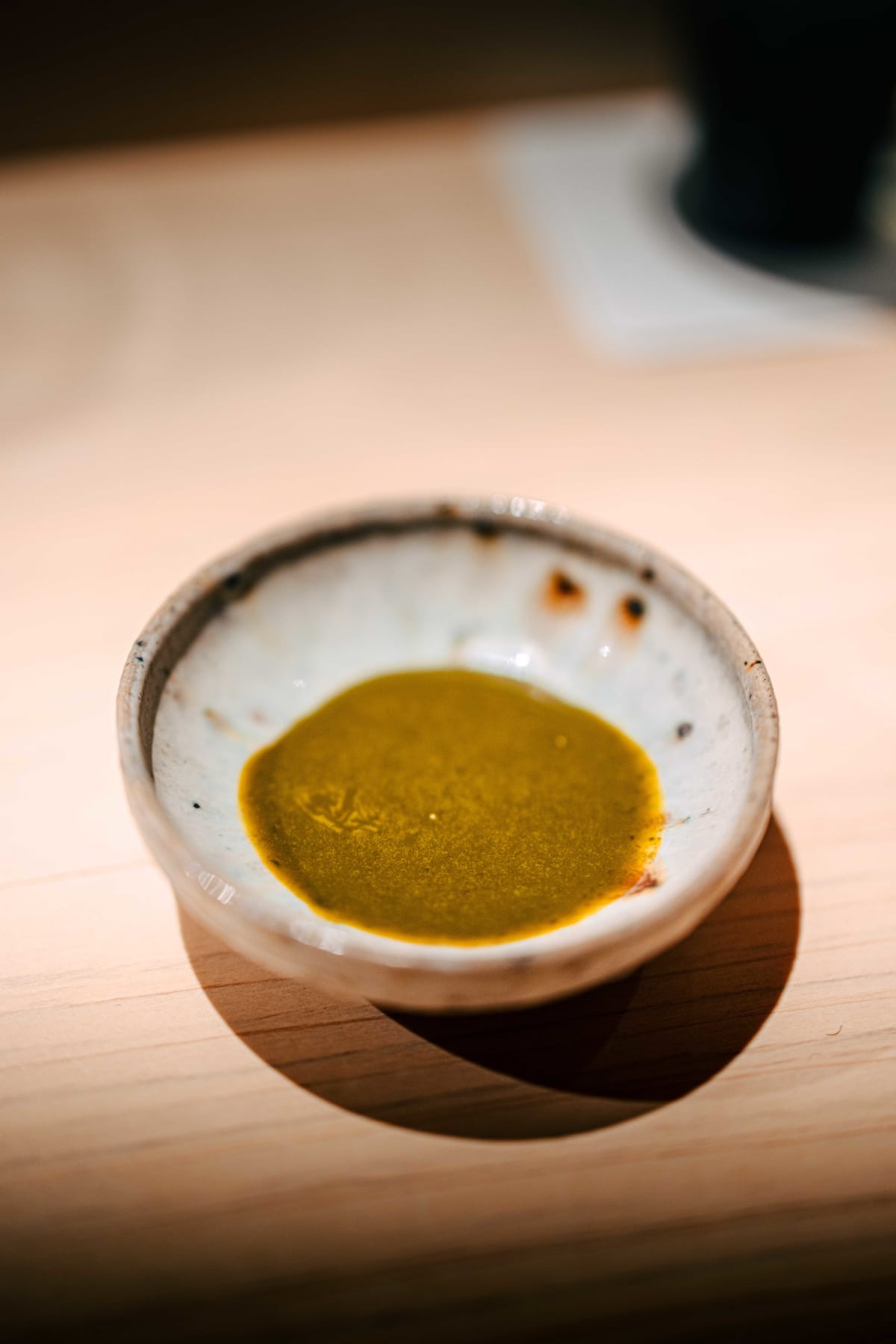 Sushi Juyon by Saito, Seoul: the abalone liver sauce in a small dish, then a little shari set on the sauce left on the plate, on both visits
