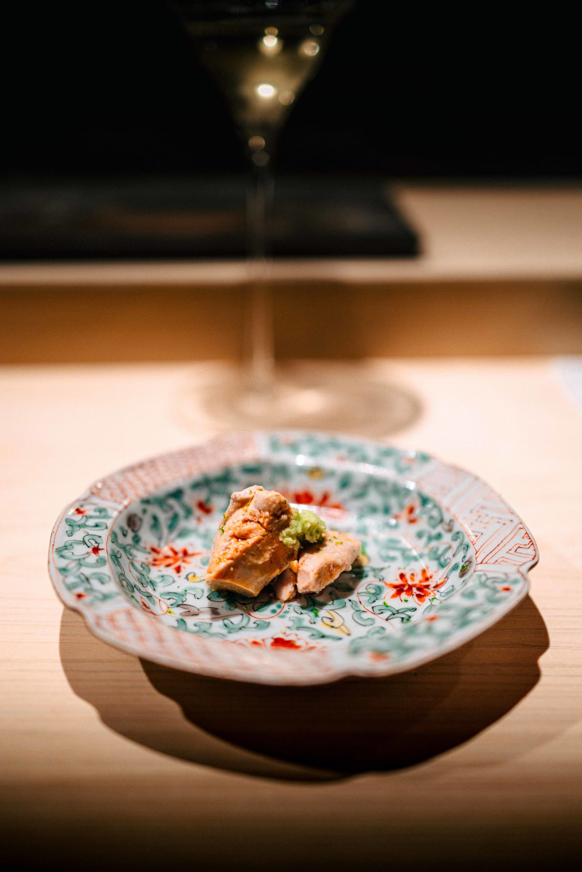 Sushi Juyon by Saito, Seoul: ankimo on a colourfully painted plate, topped with a green condiment, then up close
