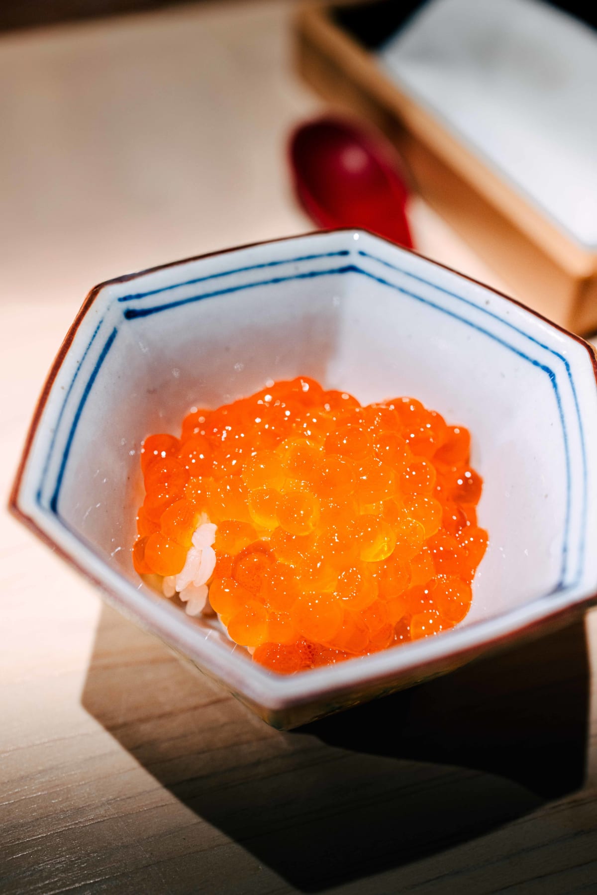 Sushi Juyon by Saito, Seoul: new-season ikura over shari in a hexagonal dish, a red spoon beside it