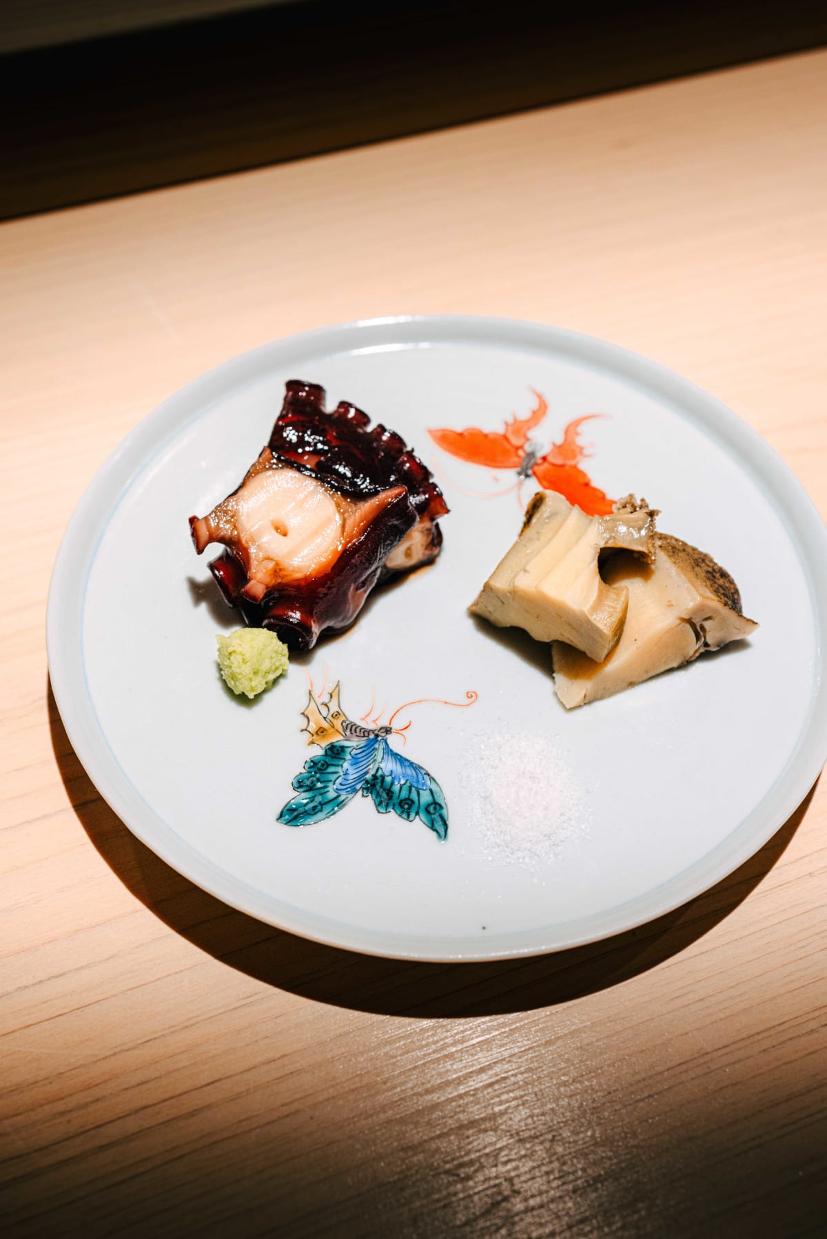 Sushi Juyon by Saito, Seoul: tako, octopus, with steamed abalone on the butterfly plate, then a piece of octopus with wasabi lifted on chopsticks