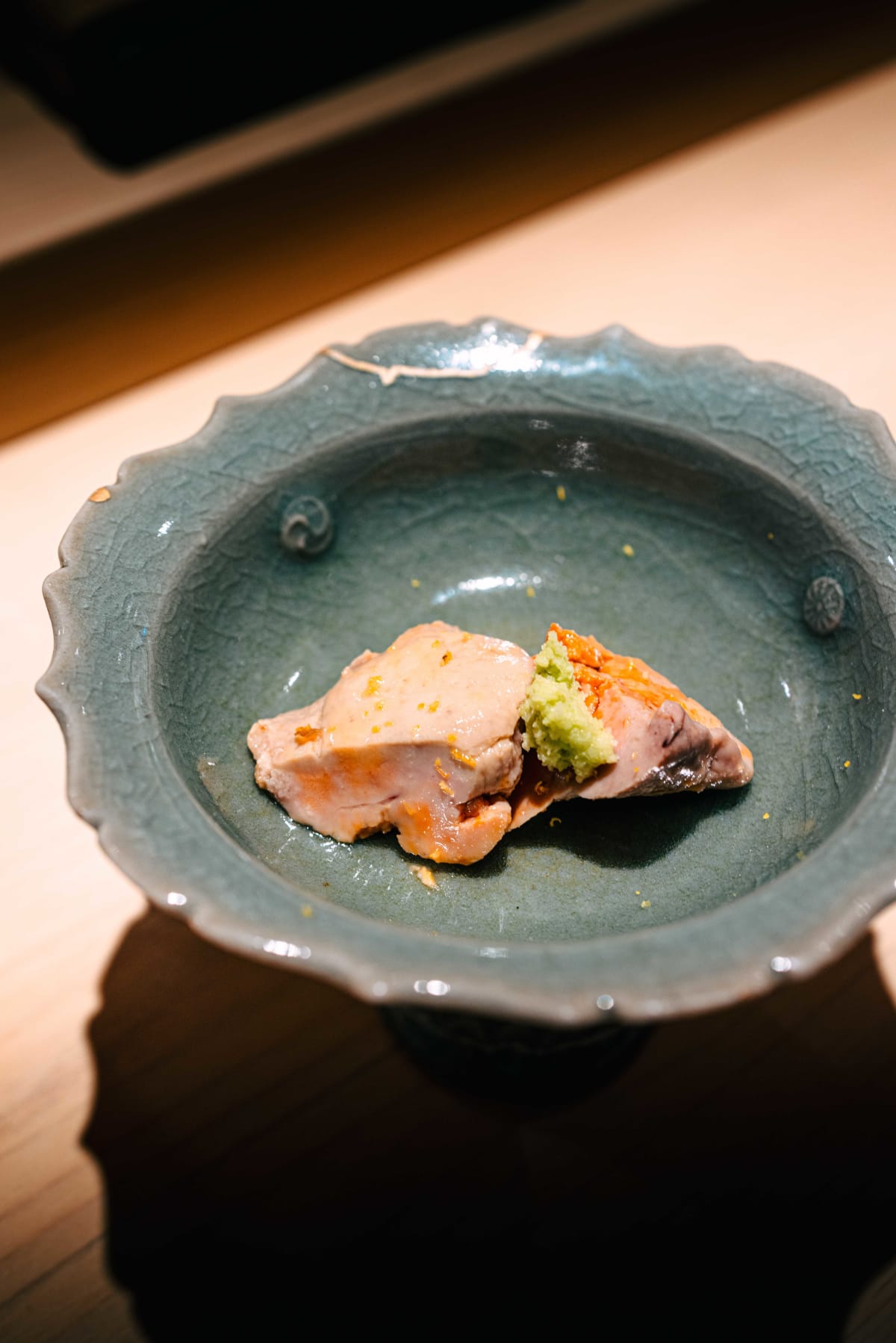 Sushi Juyon by Saito, Seoul: the second visit's ankimo in a celadon-toned footed bowl, then a piece lifted on chopsticks