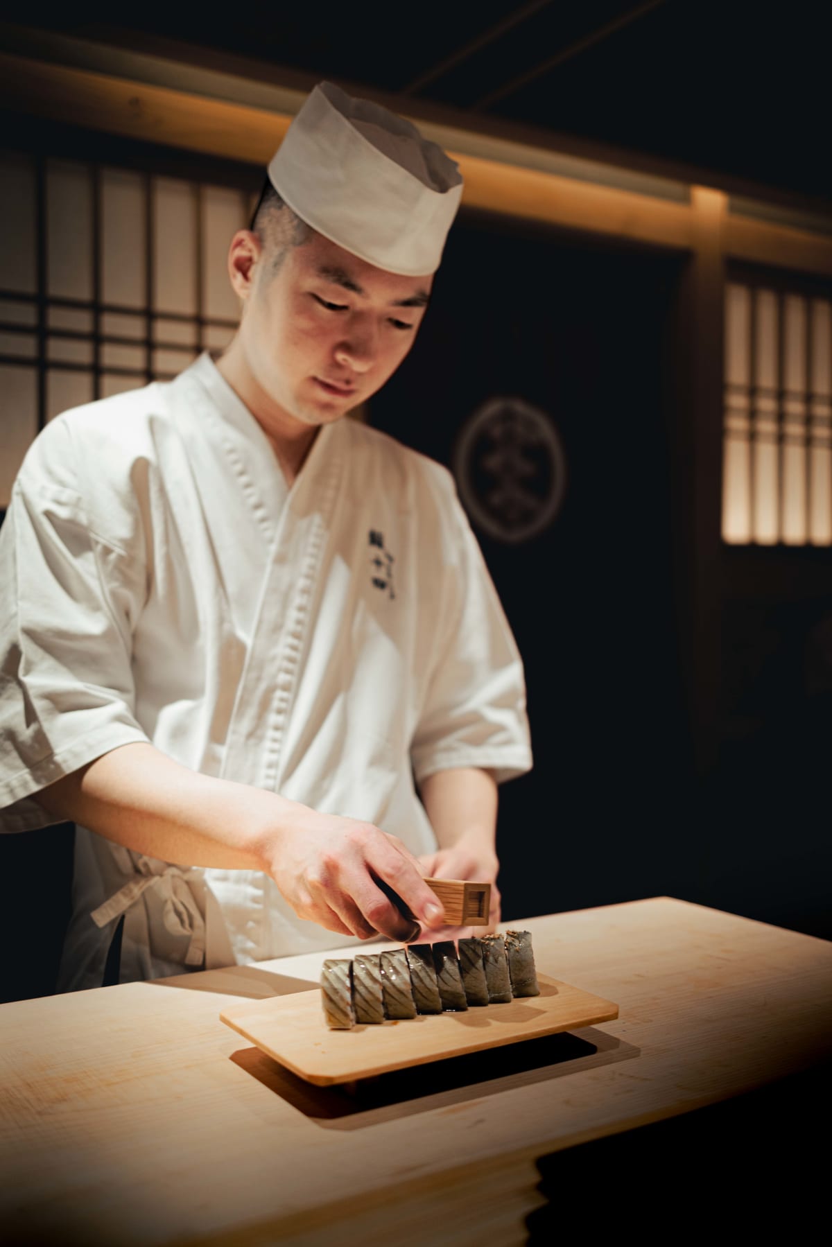 Sushi Juyon by Saito, Seoul: on the second visit, a young cook slicing the saba maki, then a piece wrapped in nori with sesame
