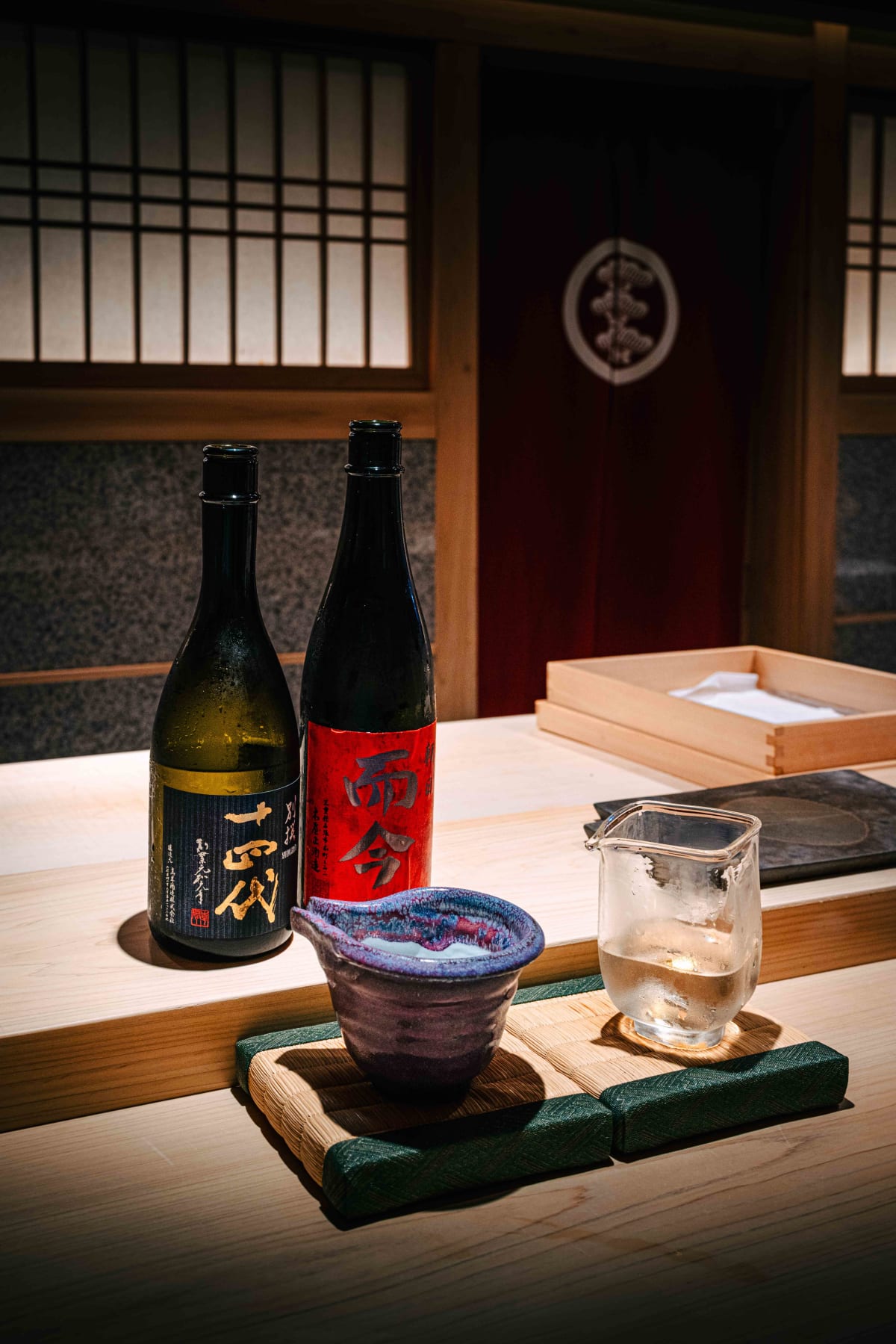 Sushi Juyon by Saito, Seoul: the two bottles with a purple-glazed ceramic tokkuri and a glass tokkuri on a tatami mat