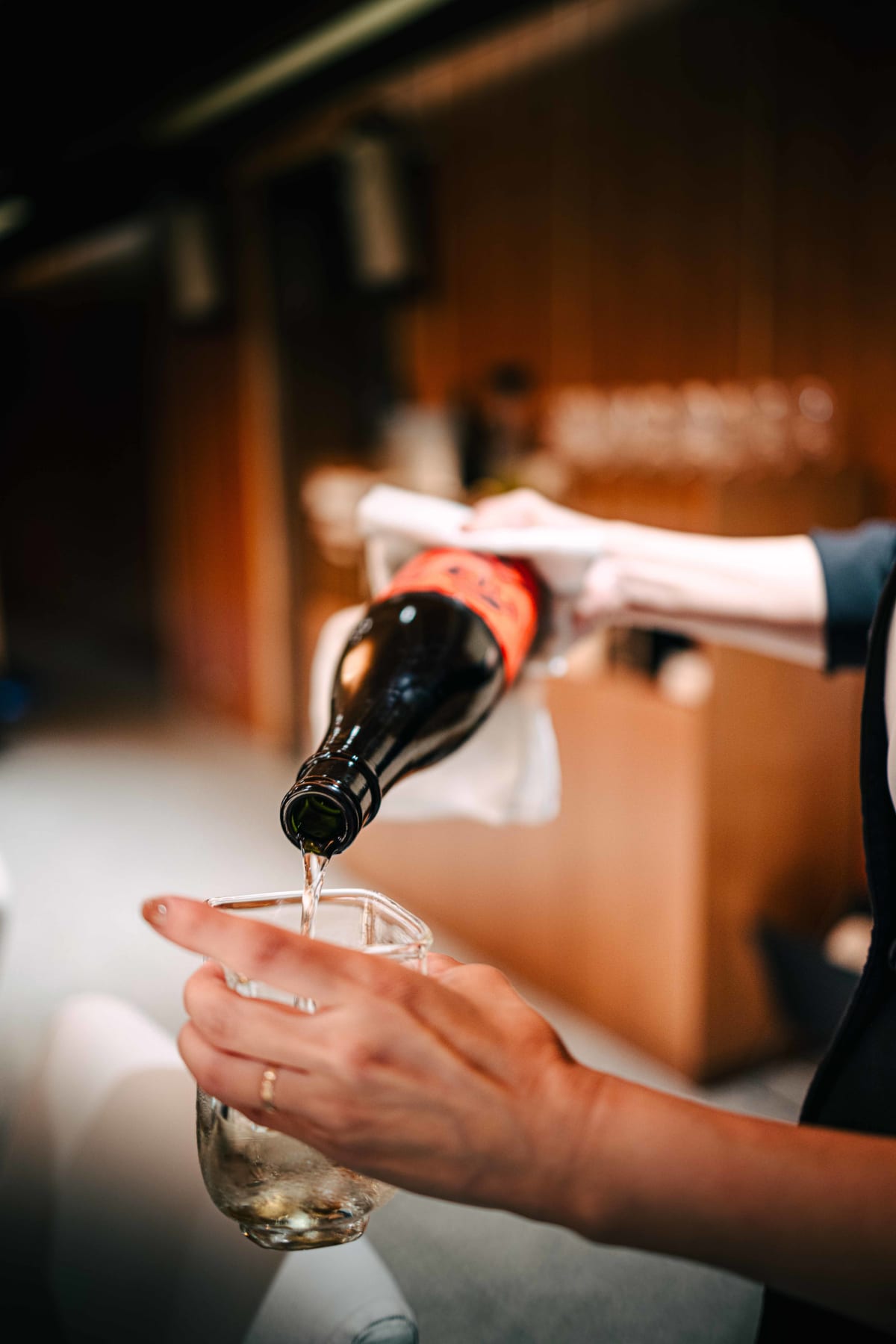 Sushi Juyon by Saito, Seoul: the Jikon, its bottle wrapped in a cloth, being poured into the glass tokkuri