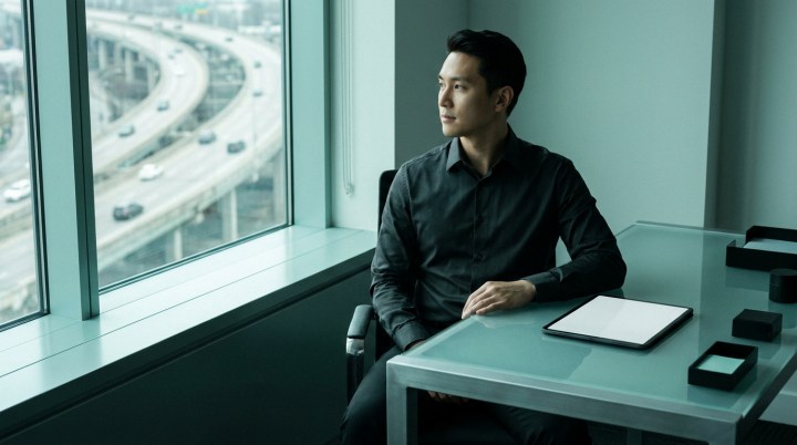 An executive at a desk looking out over a multi-level highway interchange