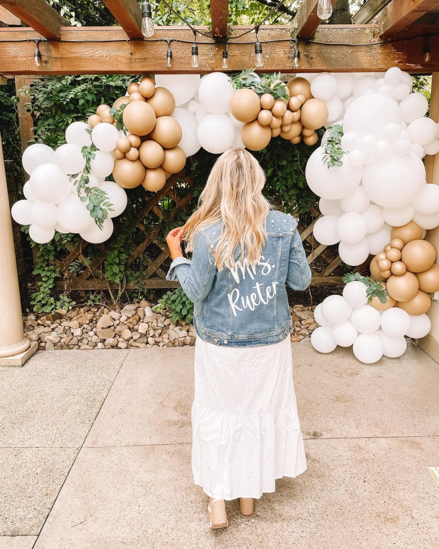 White and gold balloon arch on a pergola at a Pittsburgh engagement party