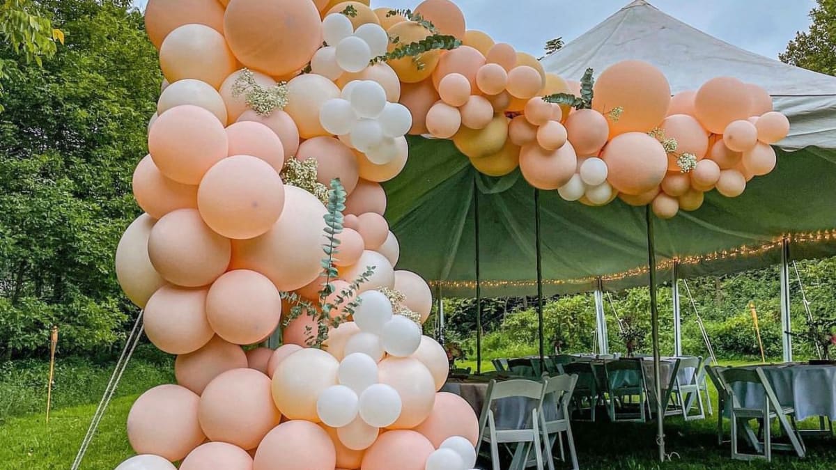 Lush pink and white balloon garland with marquee letters spelling LOVE at a Pittsburgh engagement party styled by Party on Bu