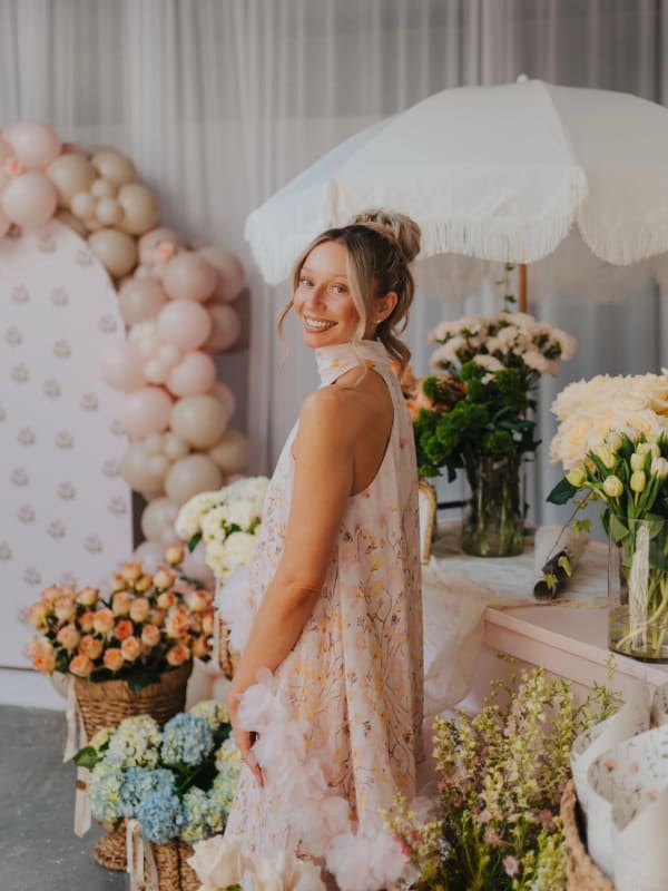 Bride beside a blush balloon garland and bloom bar at a Pittsburgh bridal shower