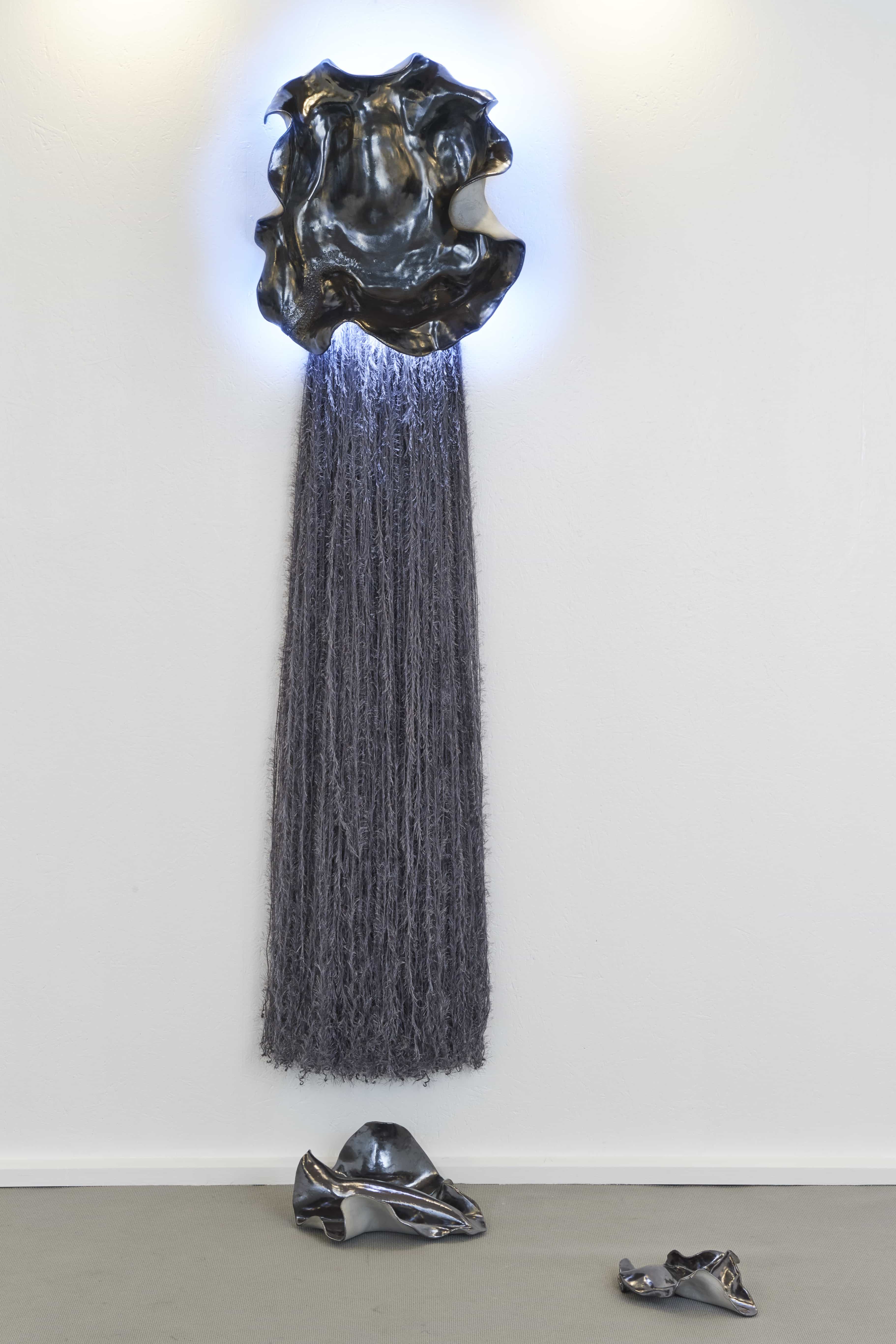 Magda von Hanau, Tupā, 2025, Clay, metallic gaze, silk strings and led lights, 204 x 56 x 18 cm