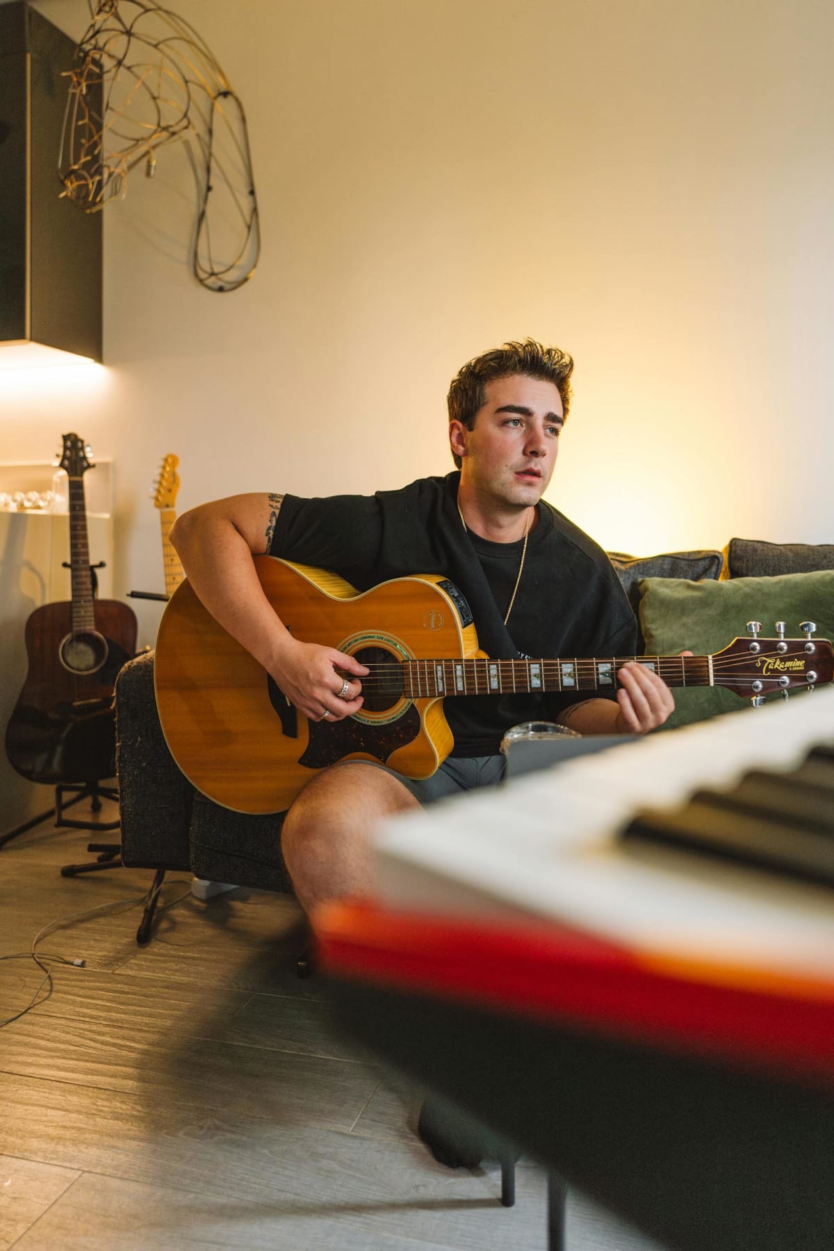Adult guitarist practicing alone at home in a living room