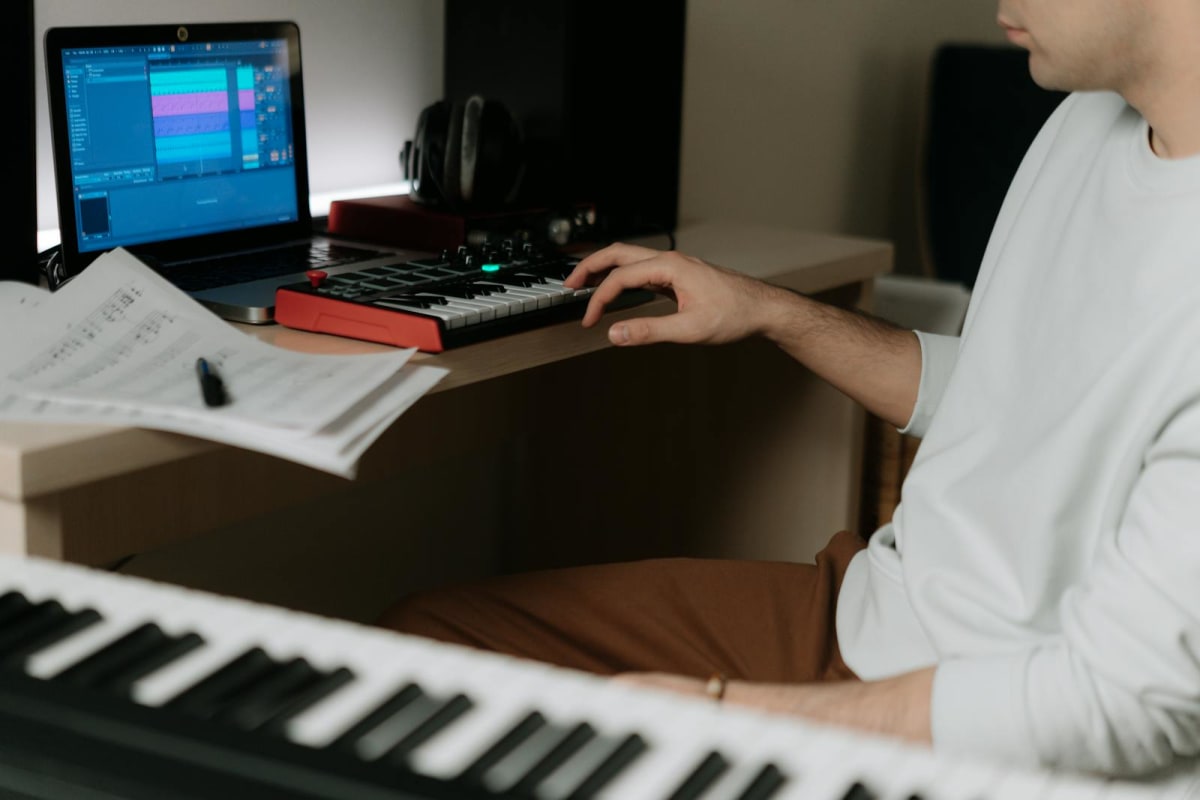Home-studio desk with keyboard, screen, and audio gear