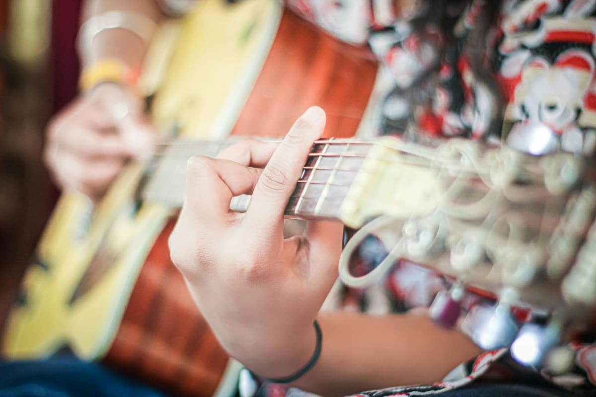 Close-up of a person practicing acoustic guitar