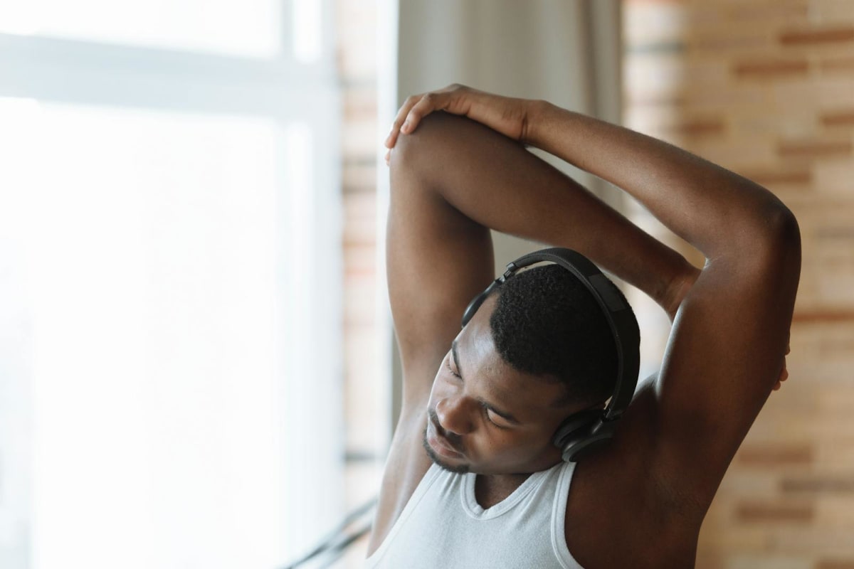 Person stretching indoors with headphones during a practice break