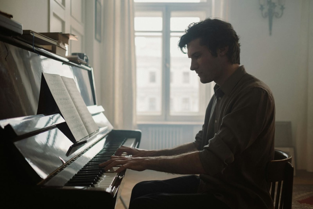 Person playing piano in a softly lit room