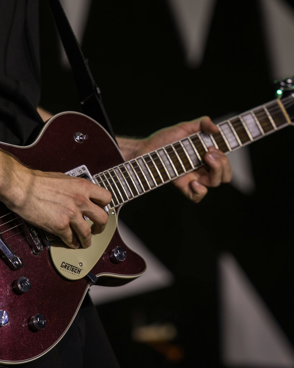 Close-up of a guitarist playing on stage during a live performance