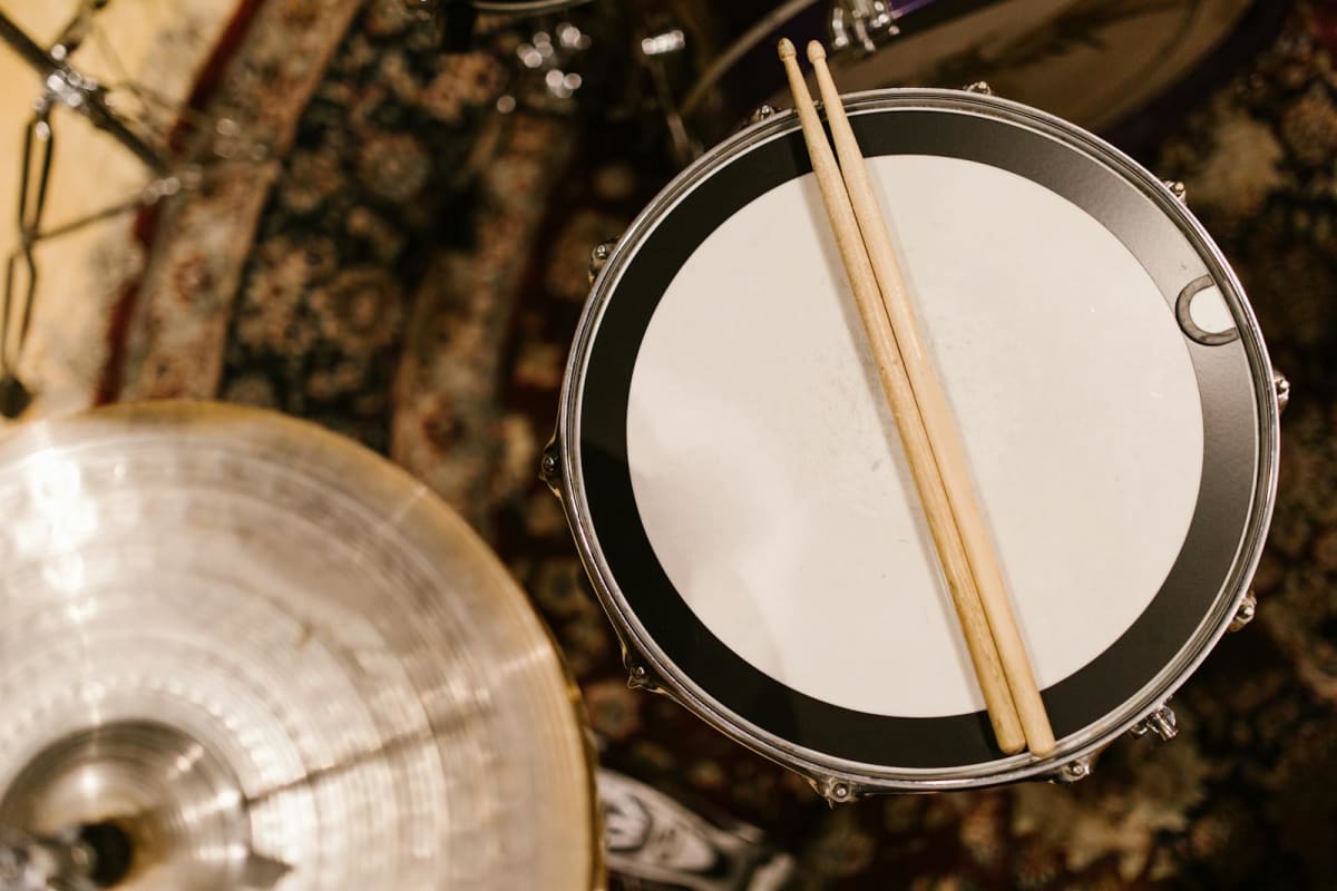 Drumsticks resting on open sheet music