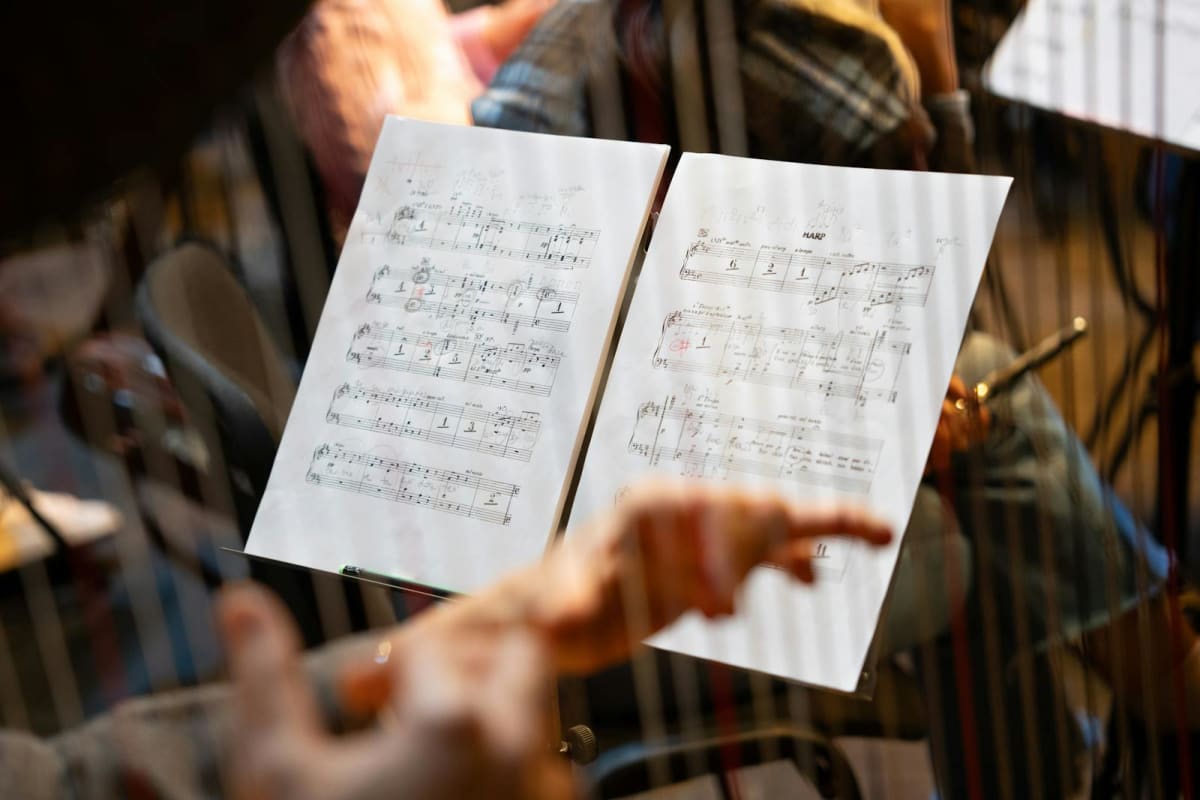 Close-up of a musician’s hands near sheet music during rehearsal