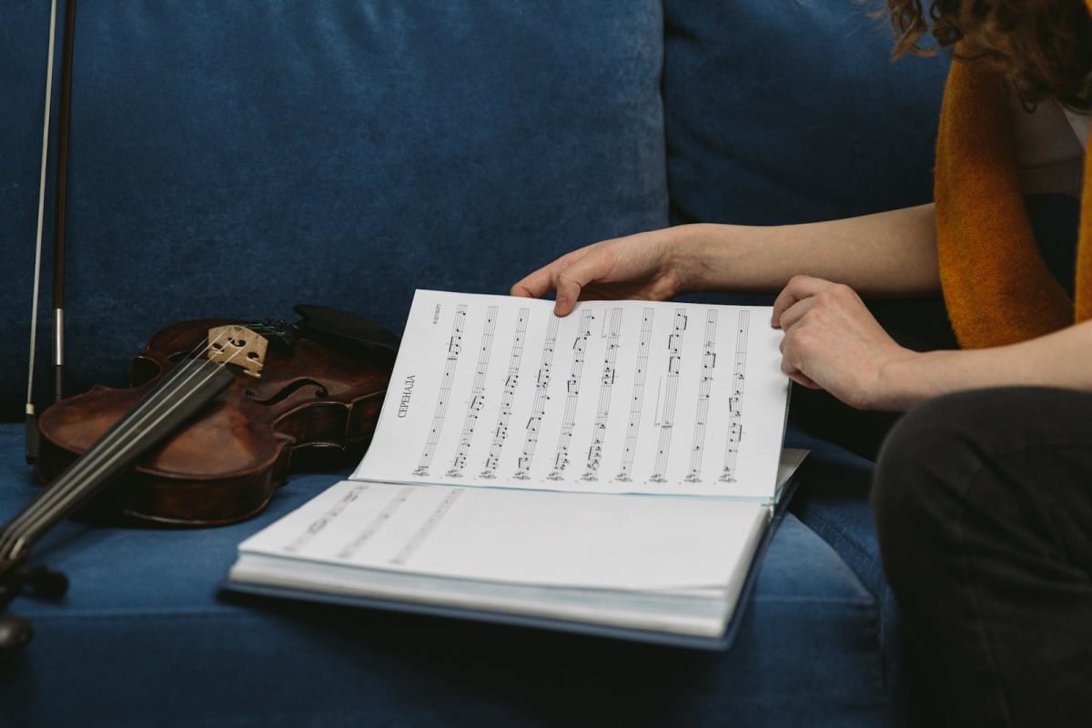 Musician reviewing sheet music with a violin nearby