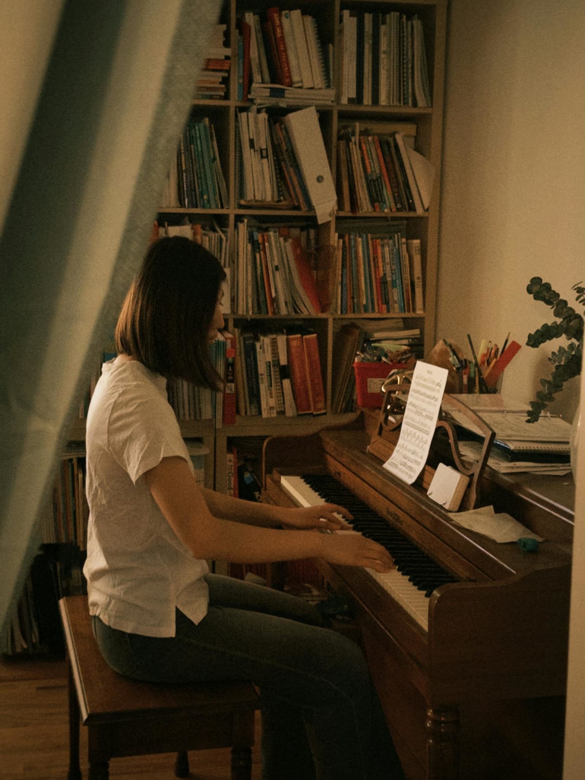 Adult practicing piano at home with sheet music