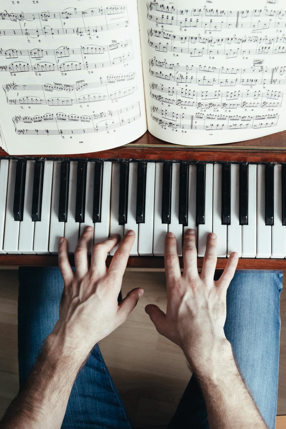 Top view of a pianist practicing with sheet music