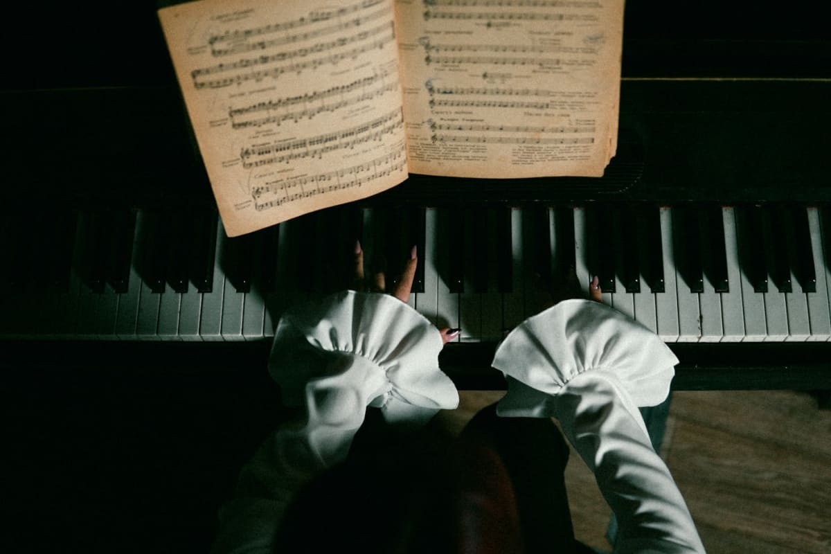 Top-view of a pianist working at the keyboard, with attention on hand position and balance