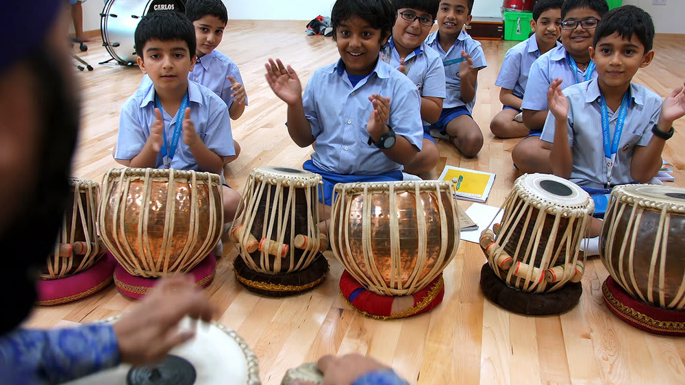Students in a smart music class playing tabla drums