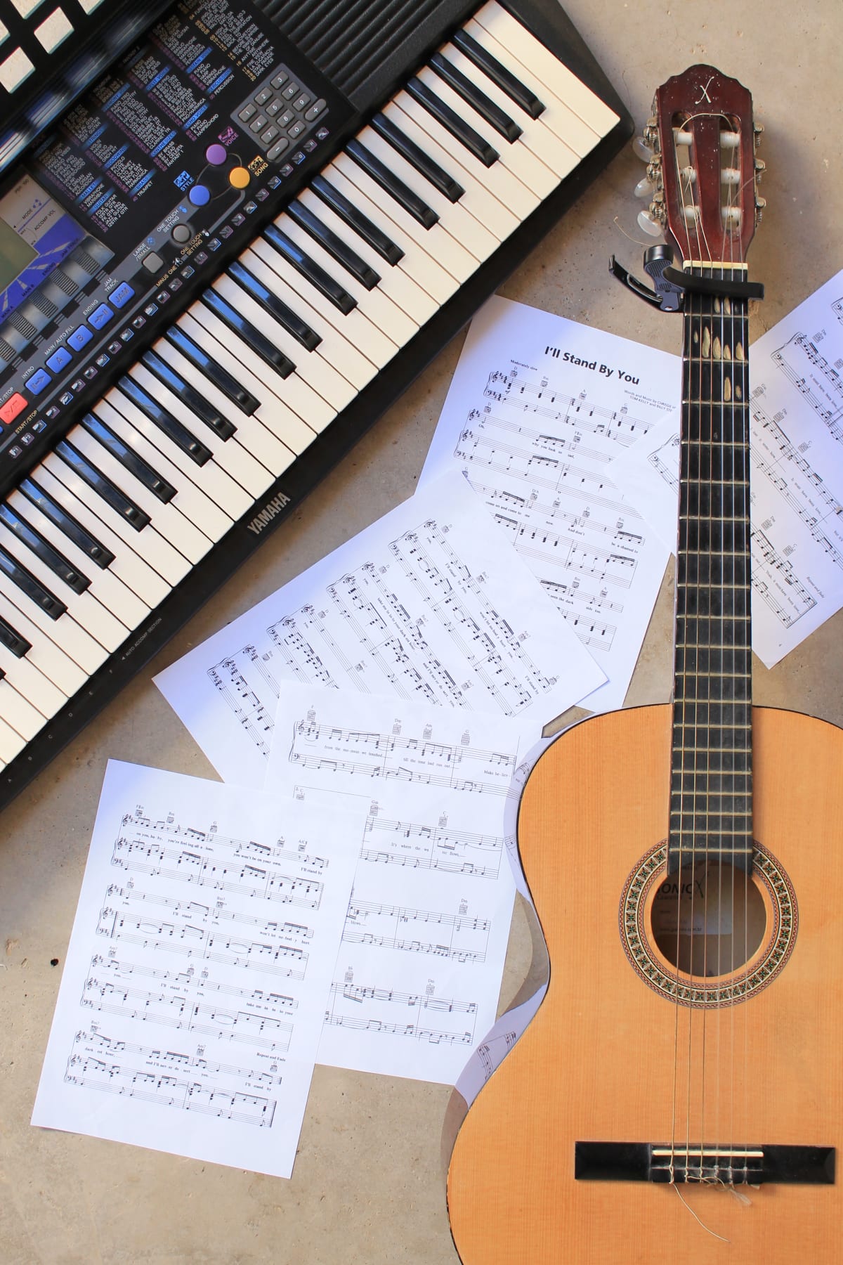Keyboard, guitar, and sheet music arranged for a music lesson