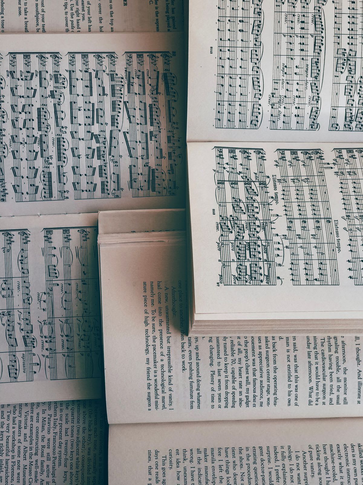 Several open music books and scores fanned out together