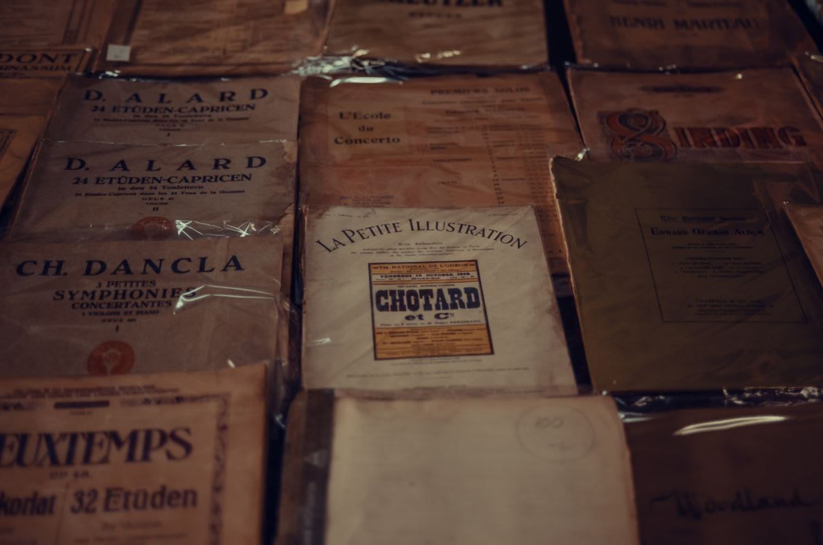 A spread of well-worn sheet music covers from different pieces