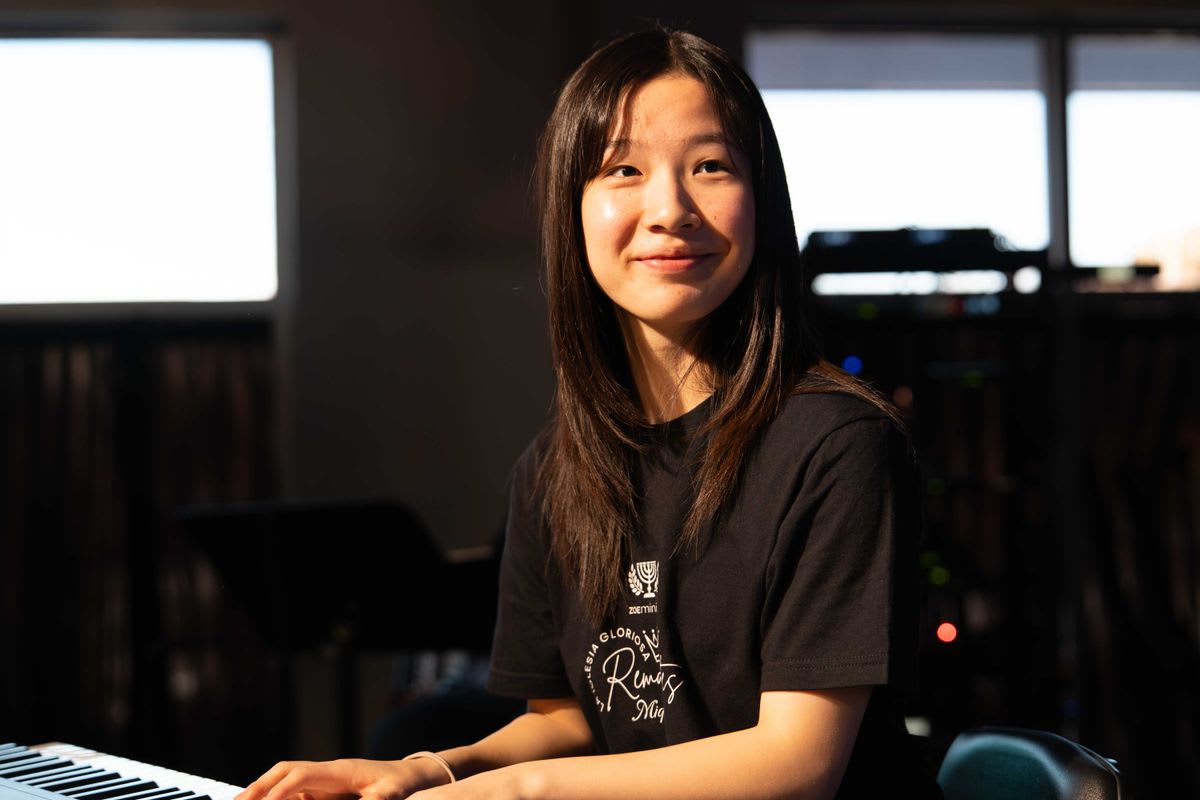 A young adult smiling contentedly at the piano after a lesson