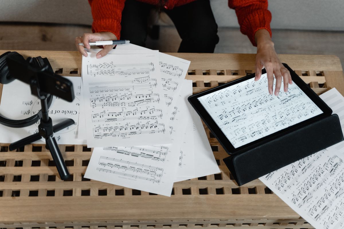 Scores, a tablet, headphones, and recording equipment arranged for music study