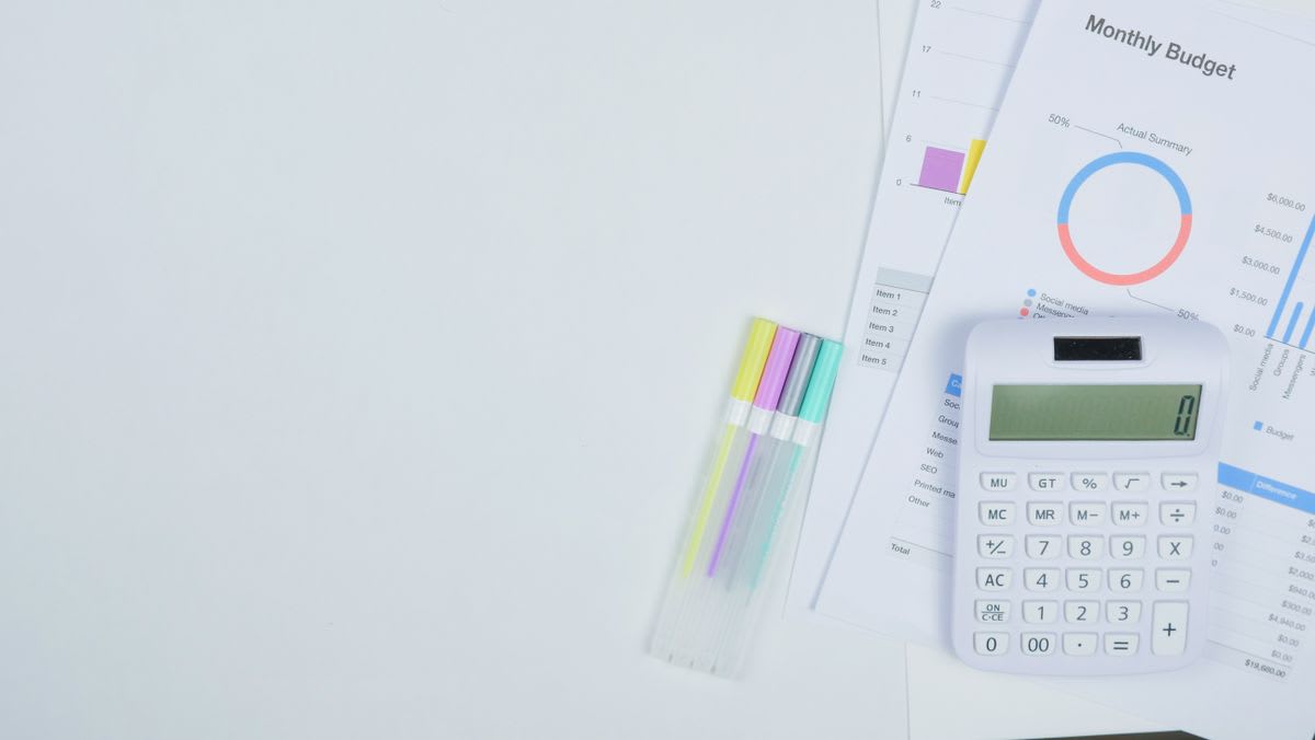 Calculator and monthly budget sheets used to plan a sustainable piano lesson rate