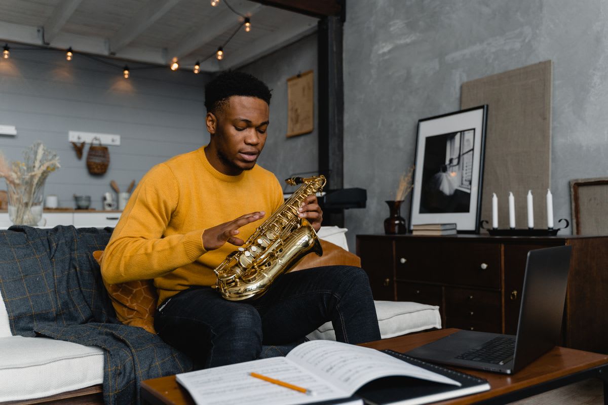 Um saxofonista revê partituras e estuda em casa