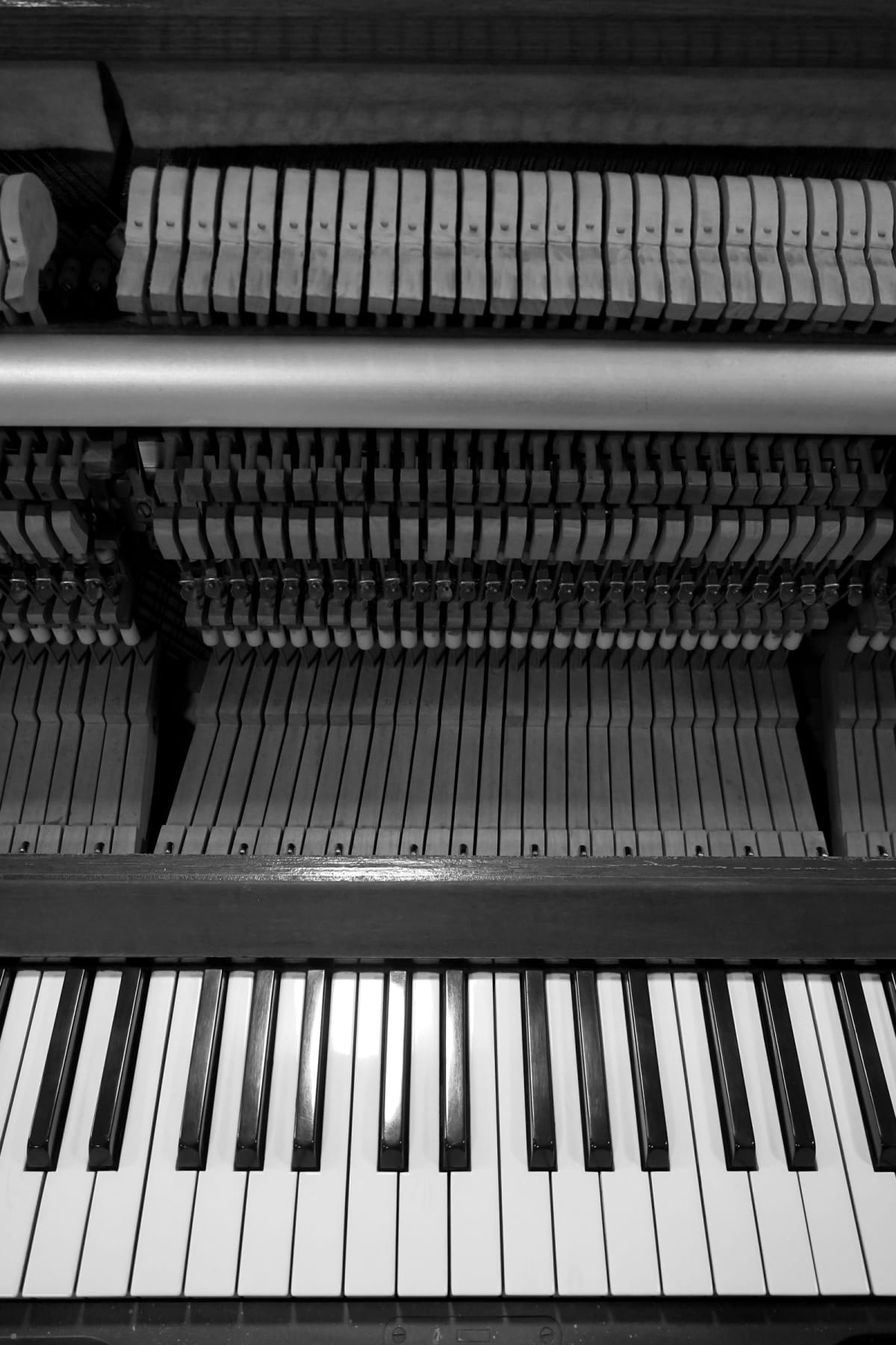 Exposed hammers and action inside an acoustic upright piano above the keyboard