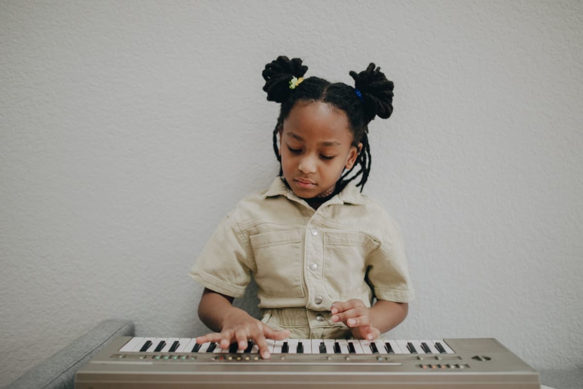 Young child exploring music on a compact mini-key keyboard at home