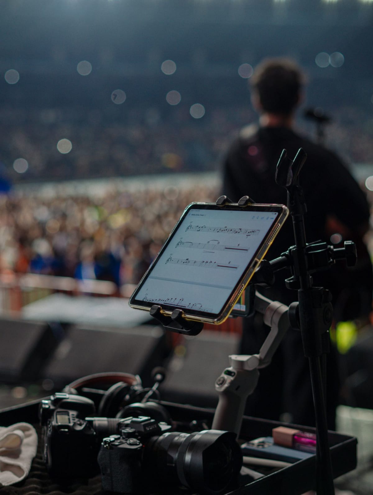 Tablet displaying a digital score mounted beside a live concert stage
