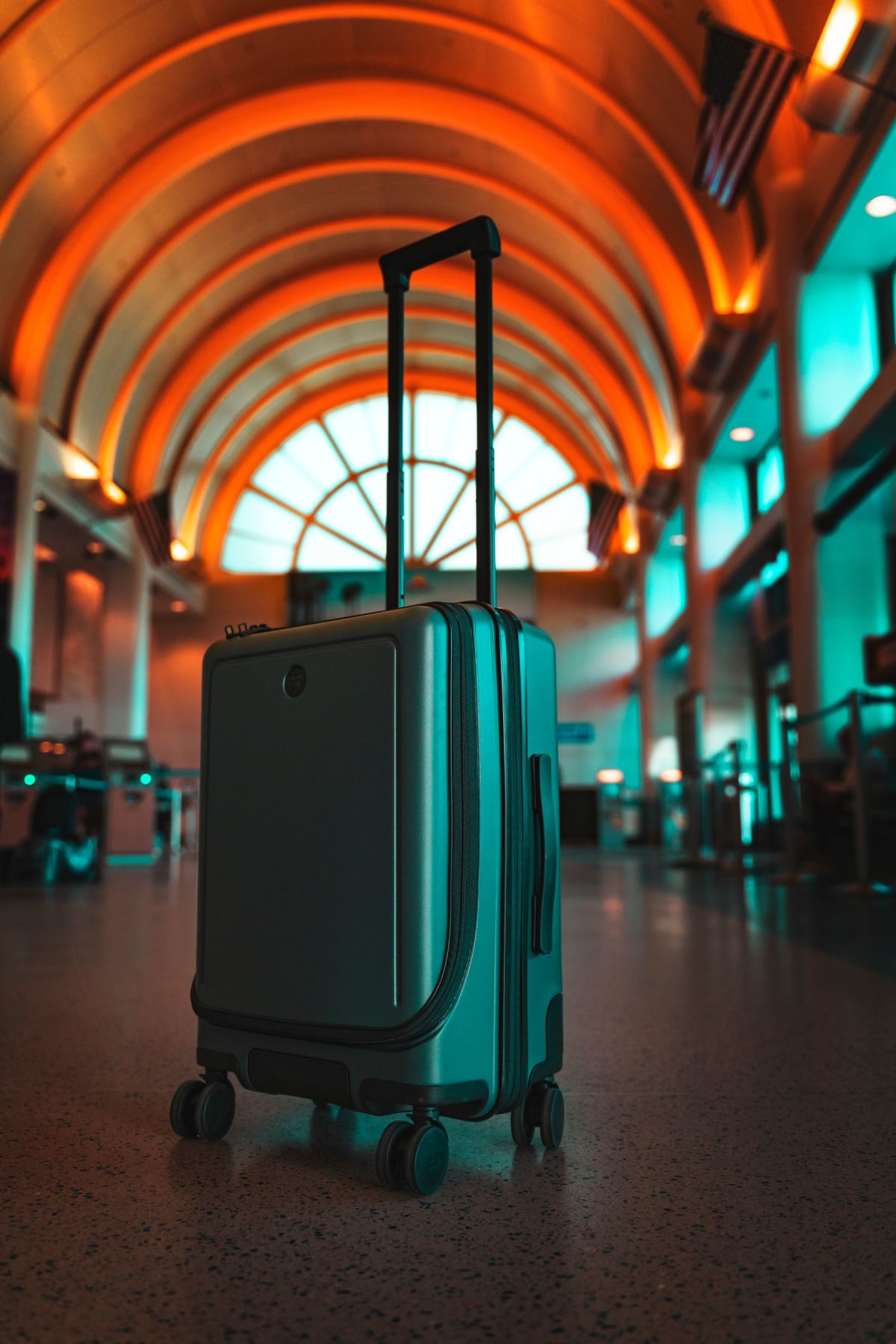 Wheeled luggage standing inside an airport terminal