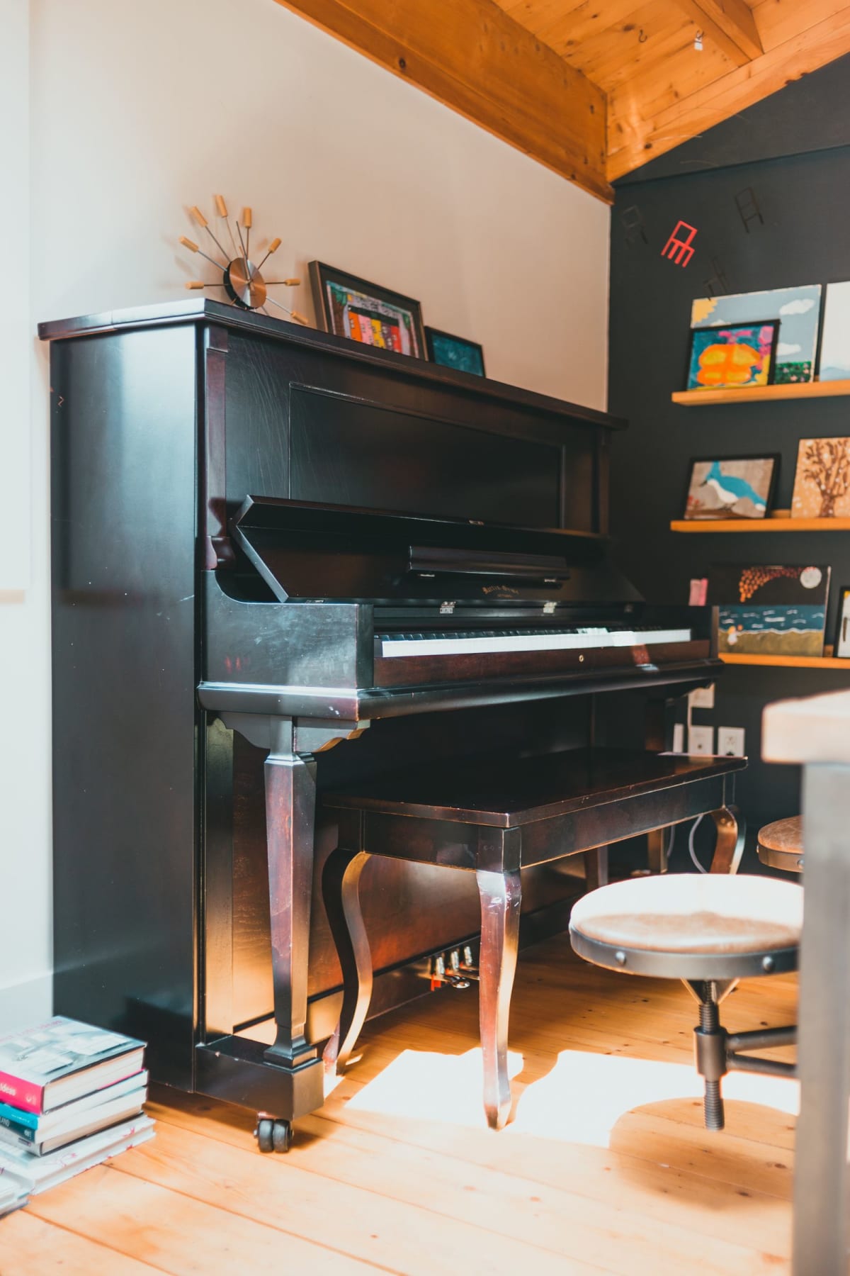 Upright piano placed on a wooden floor in a home music corner