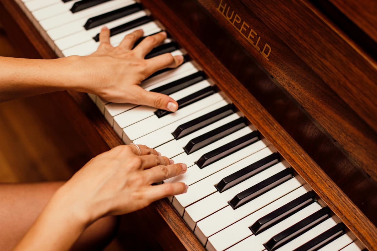 Adult hands playing piano keys in a close-up practice shot